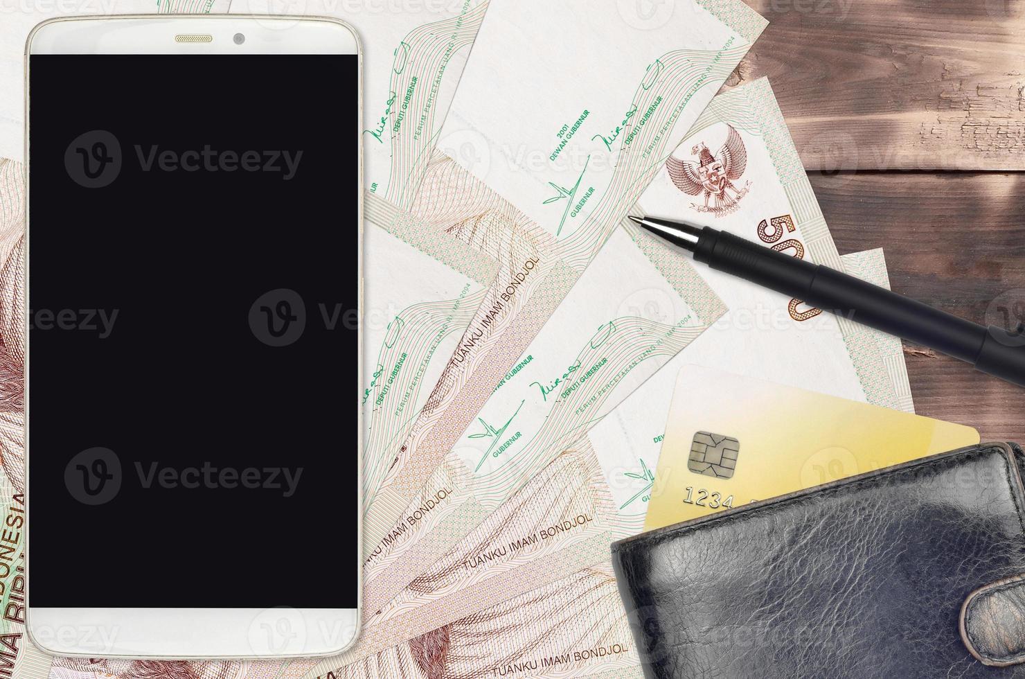 5000 indonesiska rupiah räkningar och smartphone med handväska och kreditera kort. e-betalningar eller e-handel begrepp. uppkopplad handla och företag med bärbar enheter foto