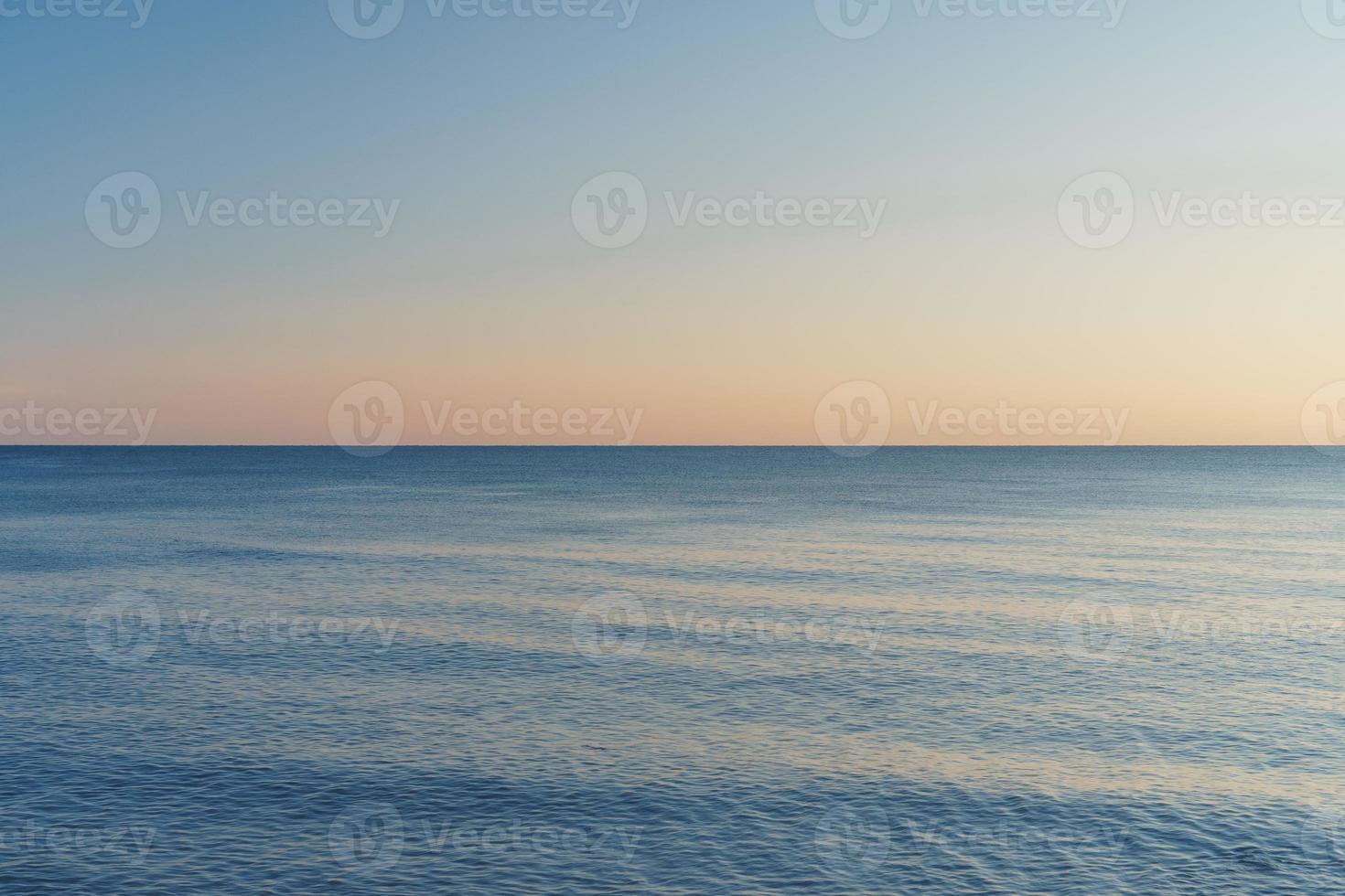 de horisont skilje de hav och de himmel in i likvärdig delar på solnedgång. foto