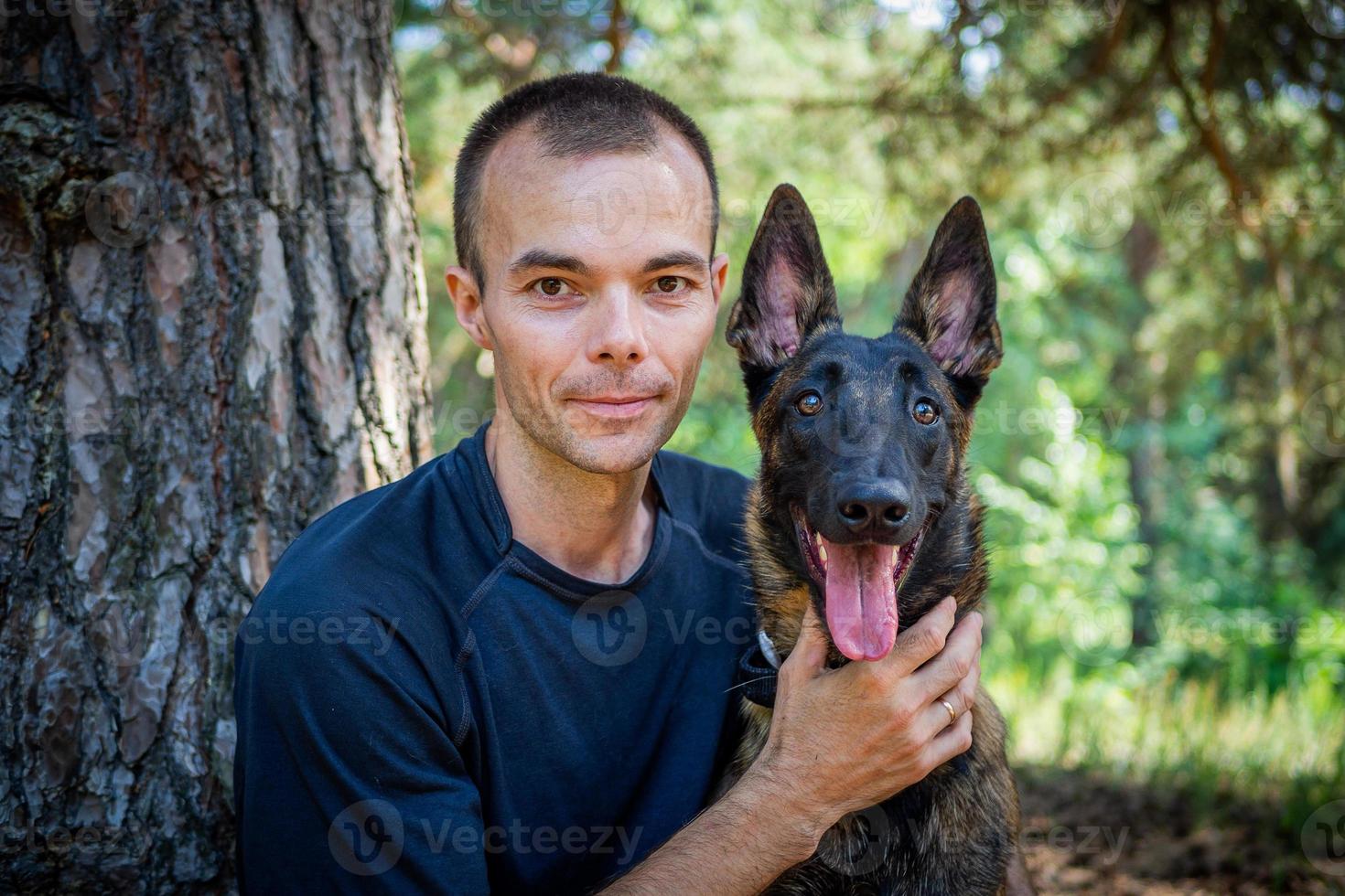 ung caucasian hipster spenderar tid med hans hund i de parkera på en solig sommar dag. de begrepp av en sällskapsdjur som en familj medlem foto