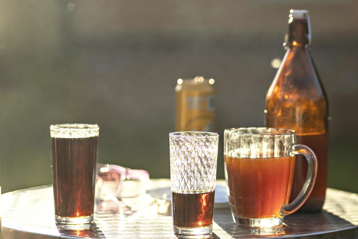 sommar kväll. färgad drycker i olika glas på de utomhus- tabell, en fest i de bakgård hus med kall drycker, en uppsättning tabell, sommar tid. foto