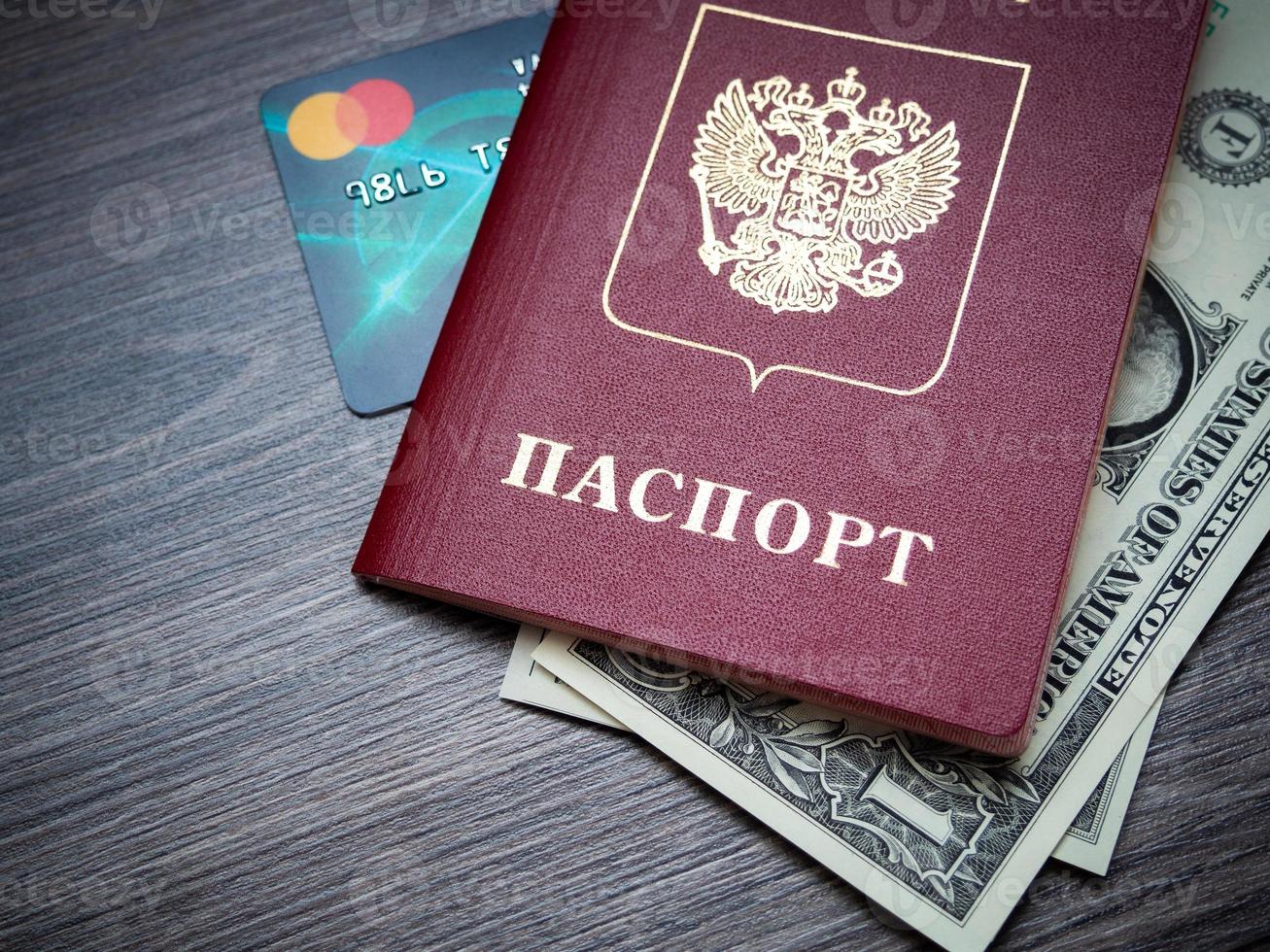 ett utländskt pass och dollar på en träbakgrund. foto