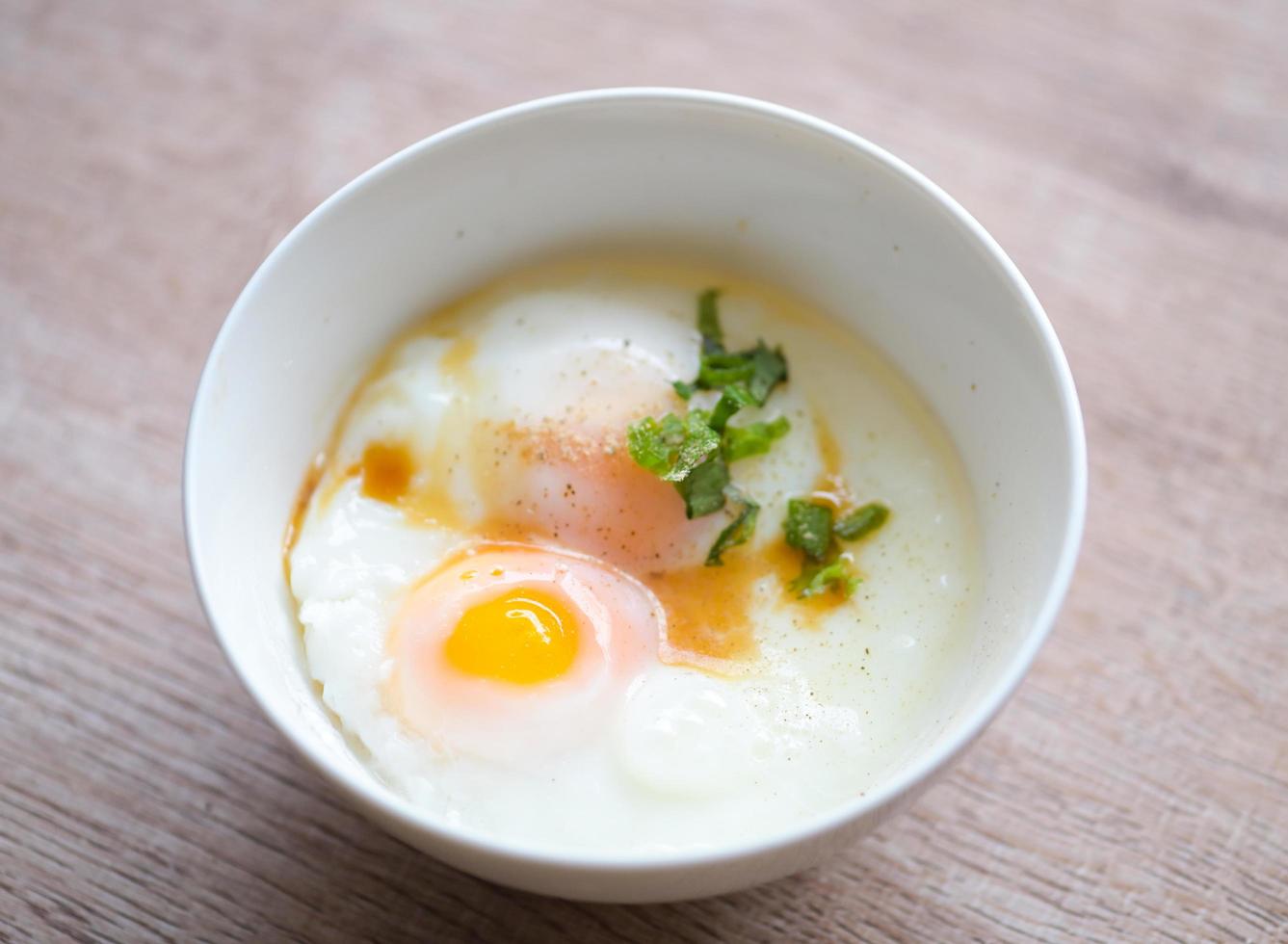 löskokt ägg på vit skål med peppar koriander på trä- tabell, ägg frukost, onsen ägg foto