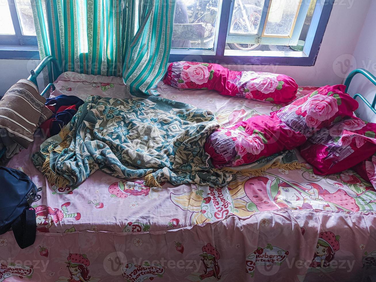 de sovrum är en röra. en barnets rum med en rörig säng och kuddar, stärker och täcken den där ha inte varit städad upp. verklig liv. foto