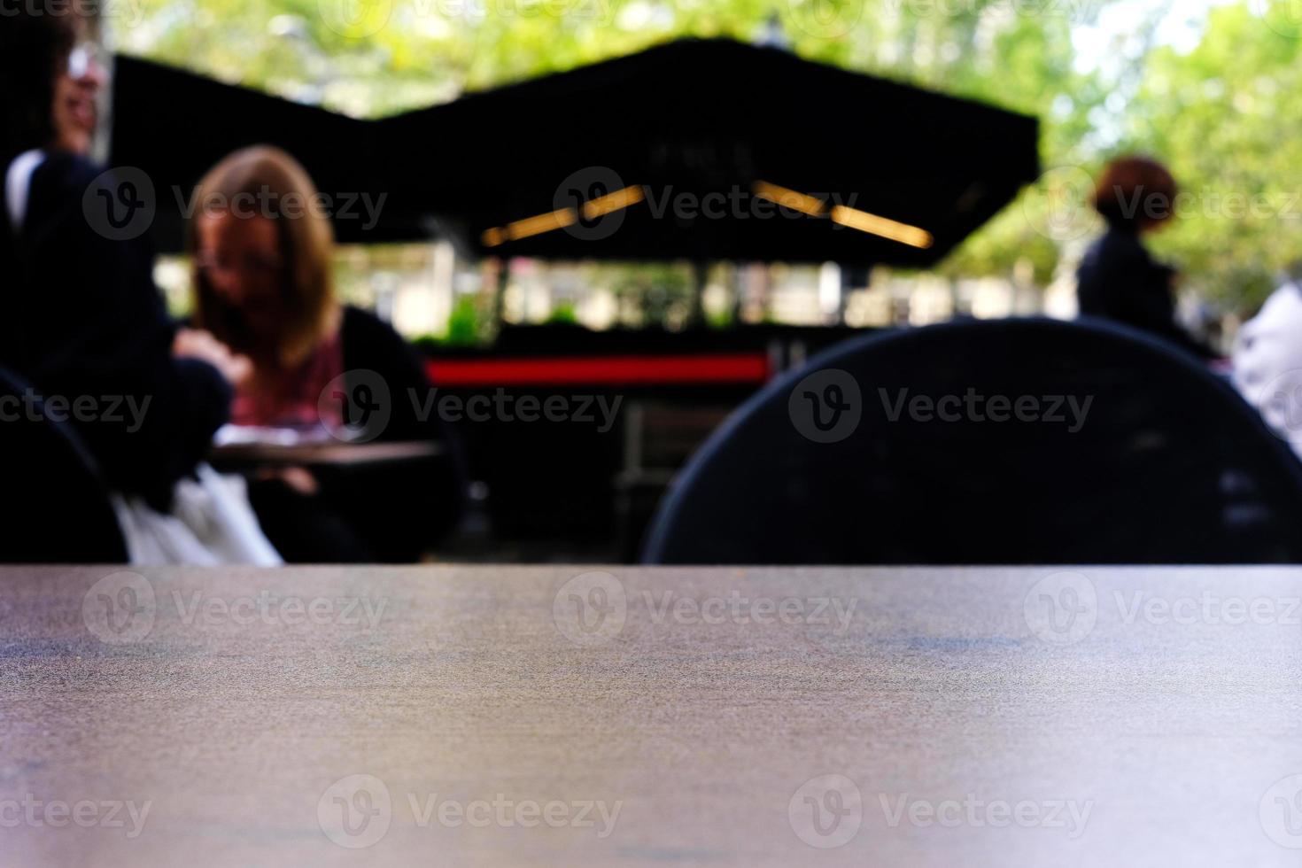 stänga upp yta av trä- tabell med Kafé utomhus- med bokeh bakgrund i selektiv fokus. foto