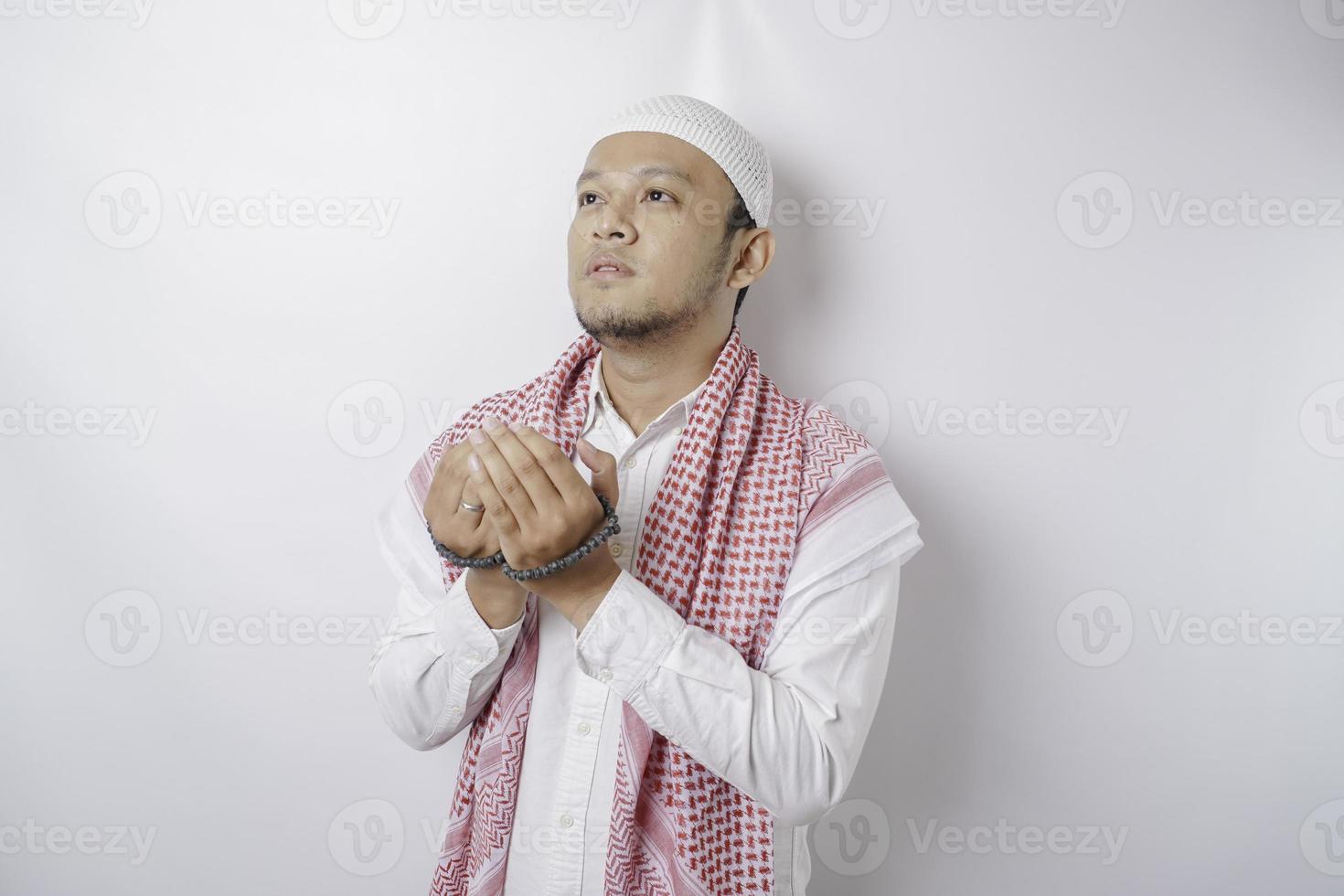 Lycklig stilig asiatisk muslim man är bön- till Gud. foto