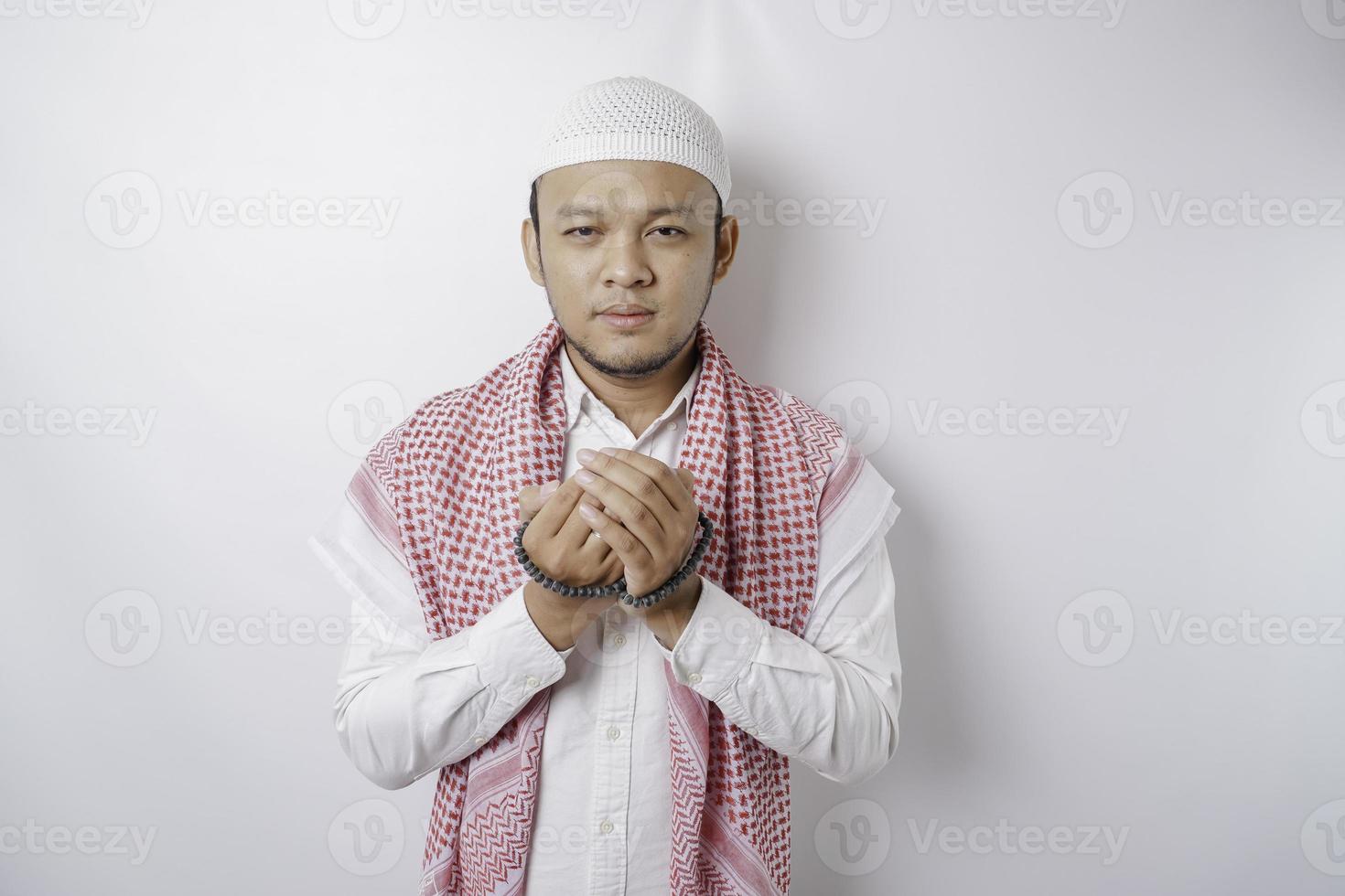 Lycklig stilig asiatisk muslim man är bön- till Gud. foto