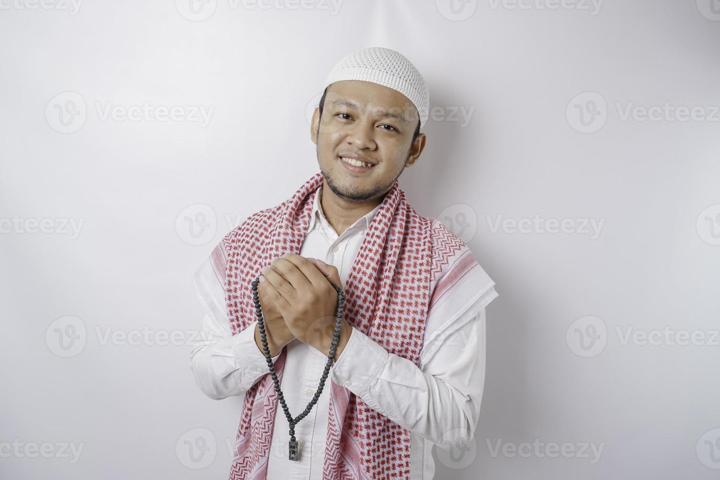 Lycklig stilig asiatisk muslim man är bön- till Gud. foto