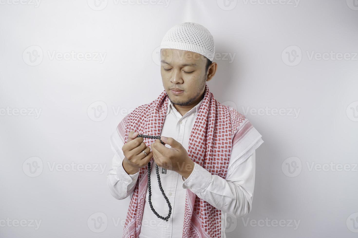 Lycklig stilig asiatisk muslim man är bön- till Gud. foto