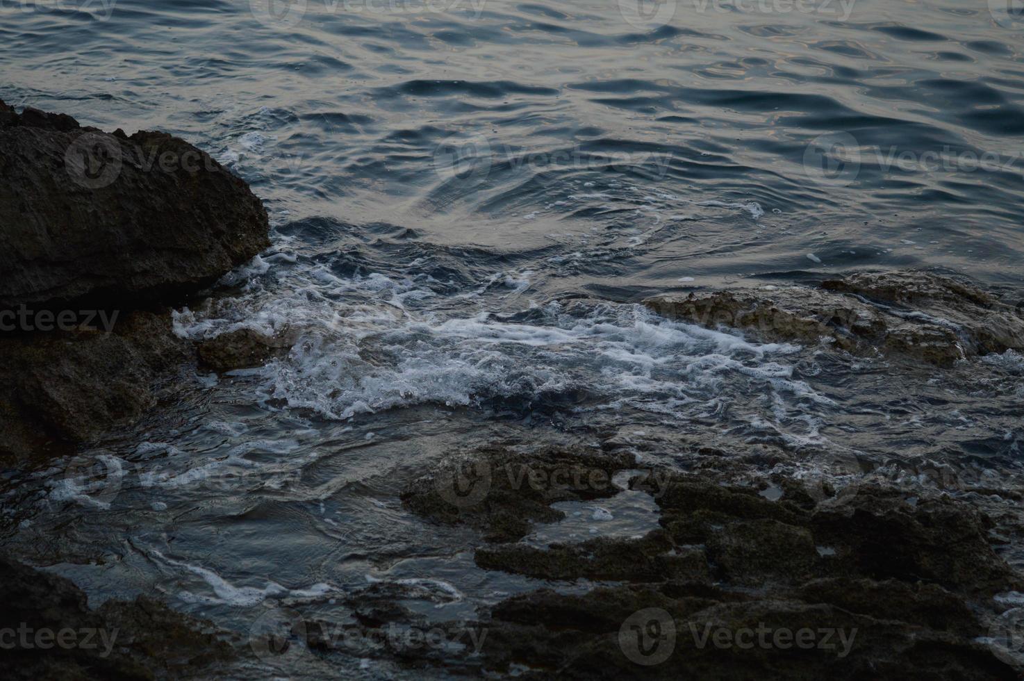 hav vågor kraschar in i stenar foto