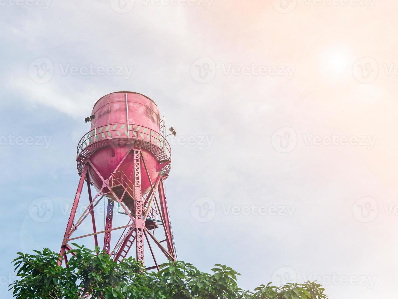 en stor rödmålad metall boka vatten tank var Uppfostrad till form en torn med en små korridor. foto