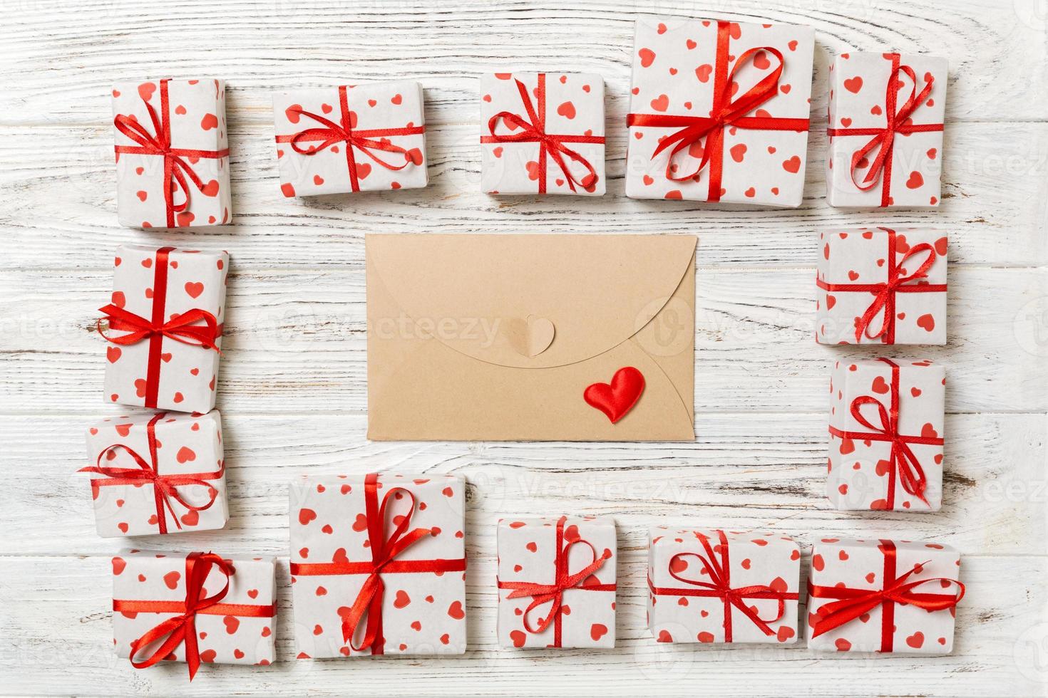 valentines dag romantisk bakgrund. kuvert kort med gåva lådor och hjärta på en trä- bakgrund foto