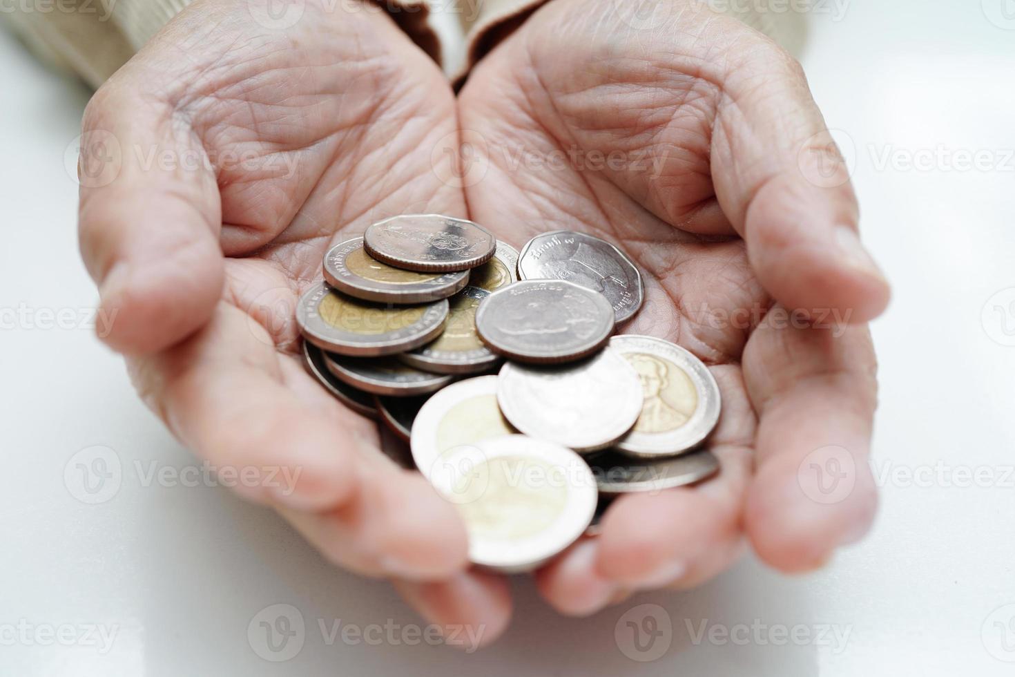 pensionerad äldre kvinna räkning mynt pengar och oroa handla om en gång i månaden kostnader och behandling avgift betalning. foto