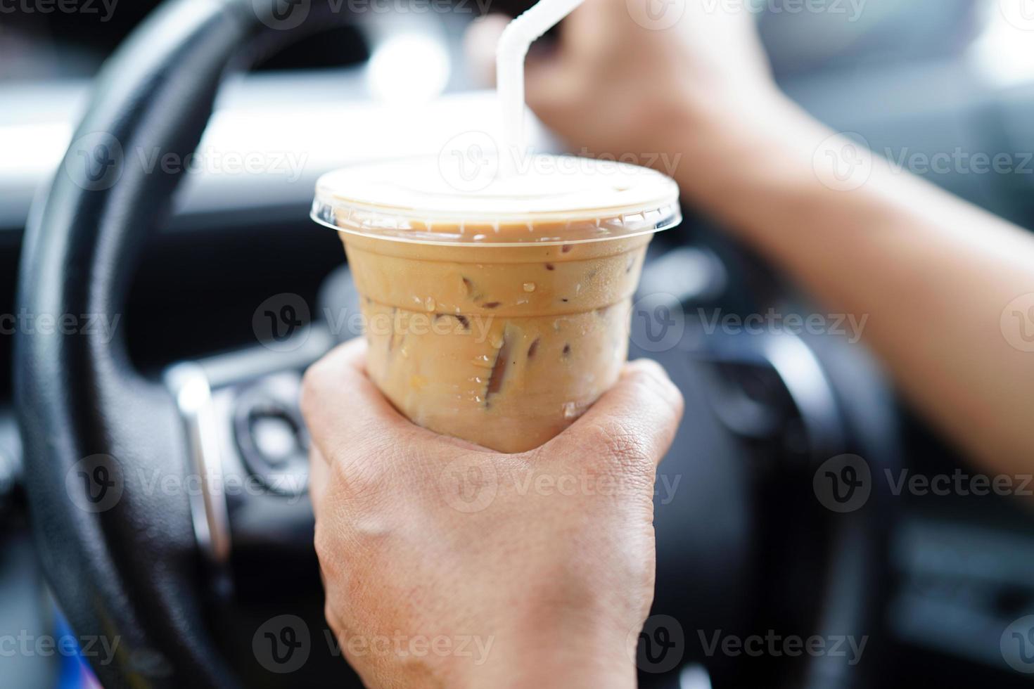 Bangkok, thailand - Maj 15, 2022 asiatisk kvinna förare håll is kaffe kopp för dryck i bil, farlig och risk ett olycka. foto