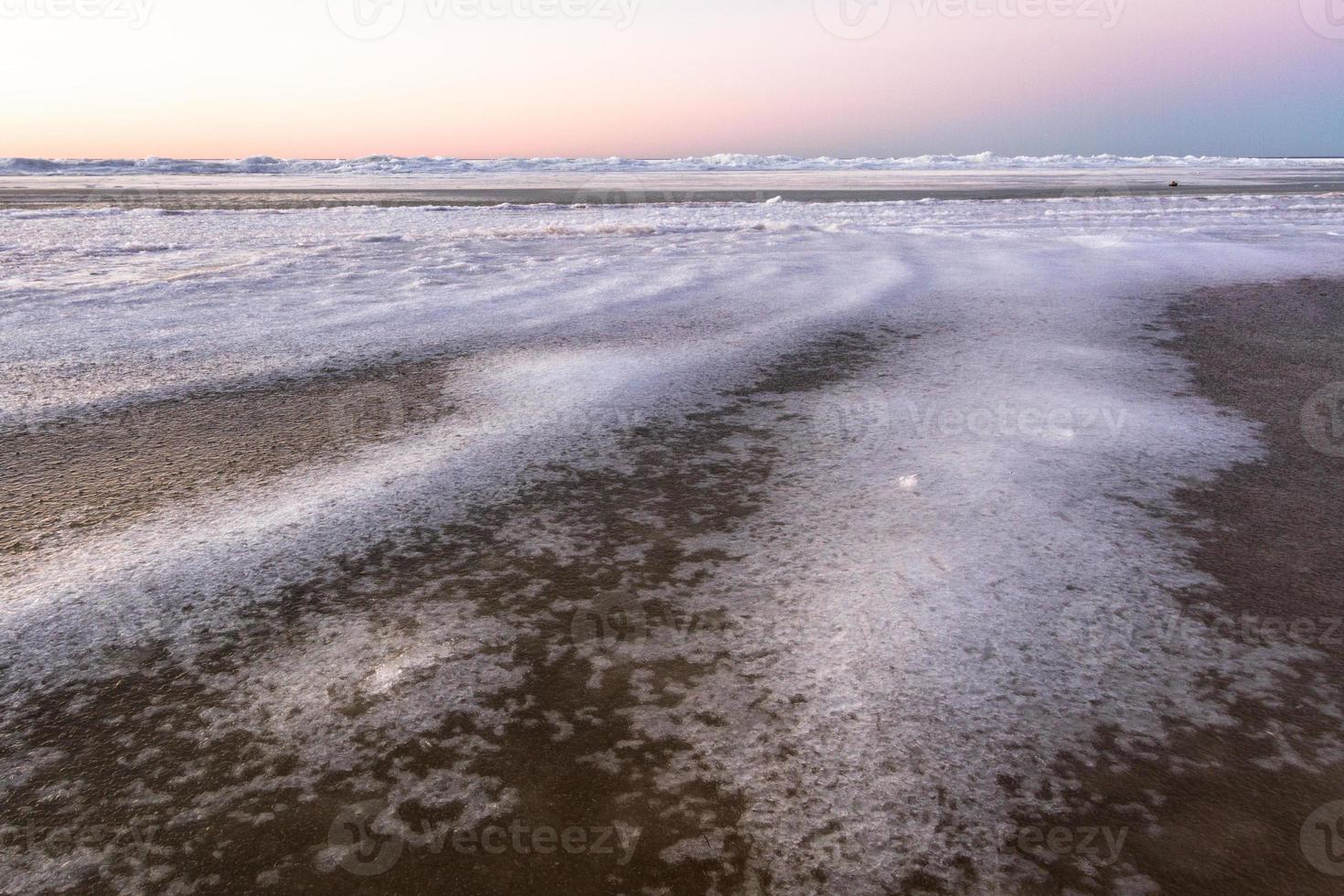 baltic hav kust med småsten och is på solnedgång foto