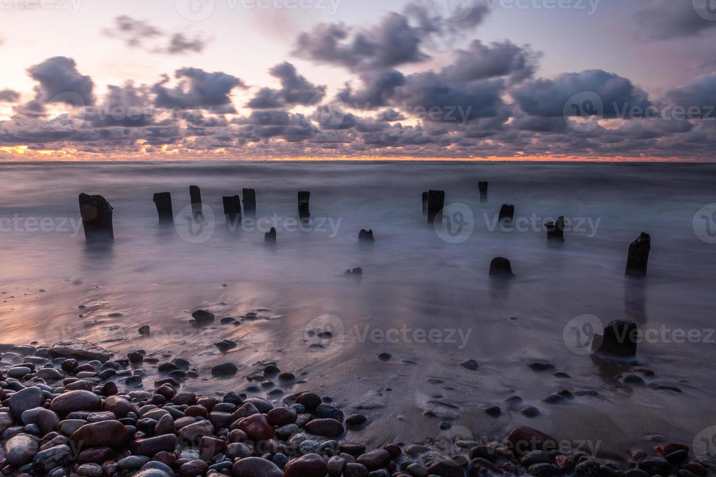 baltic hav kust med småsten och is på solnedgång foto