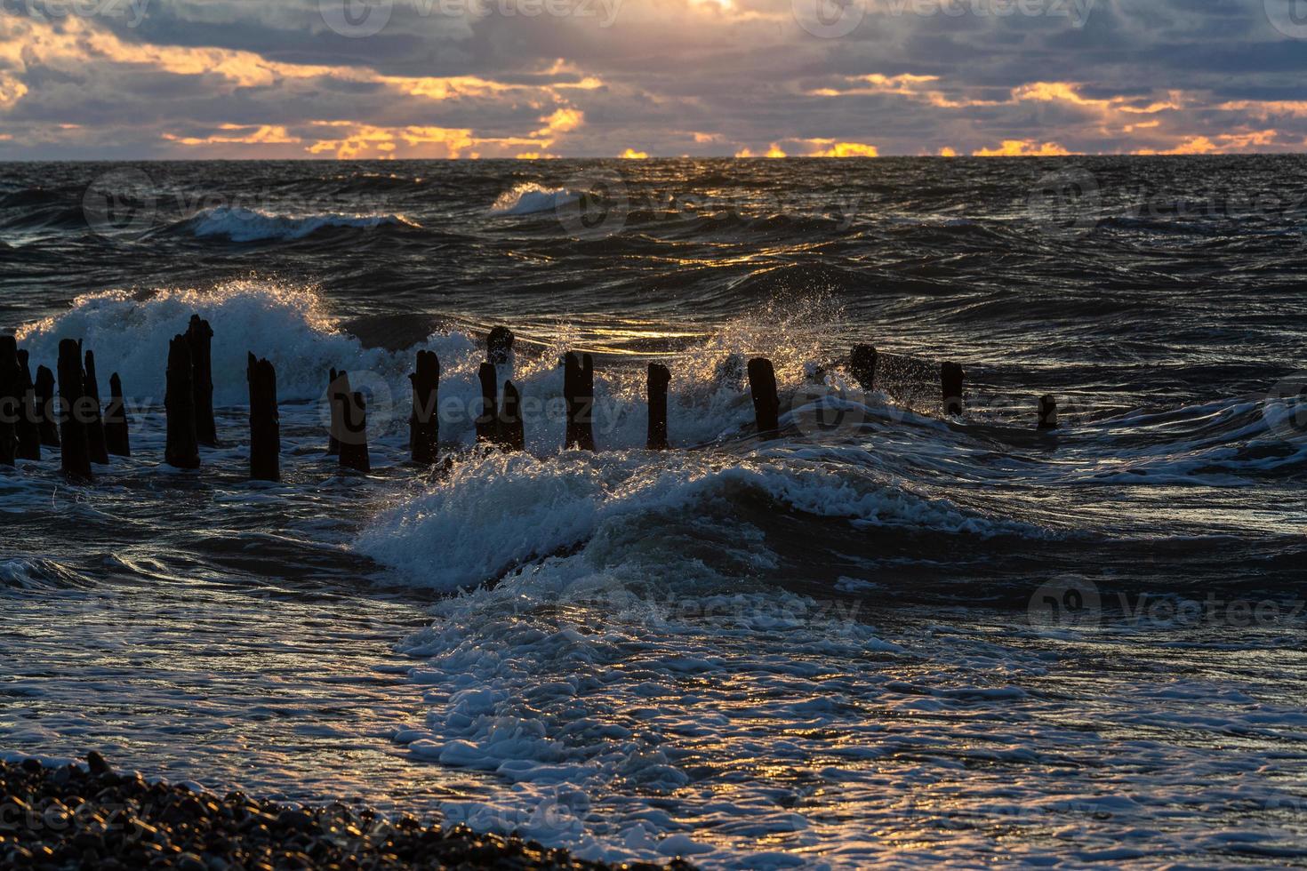 baltic hav kust med småsten och is på solnedgång foto