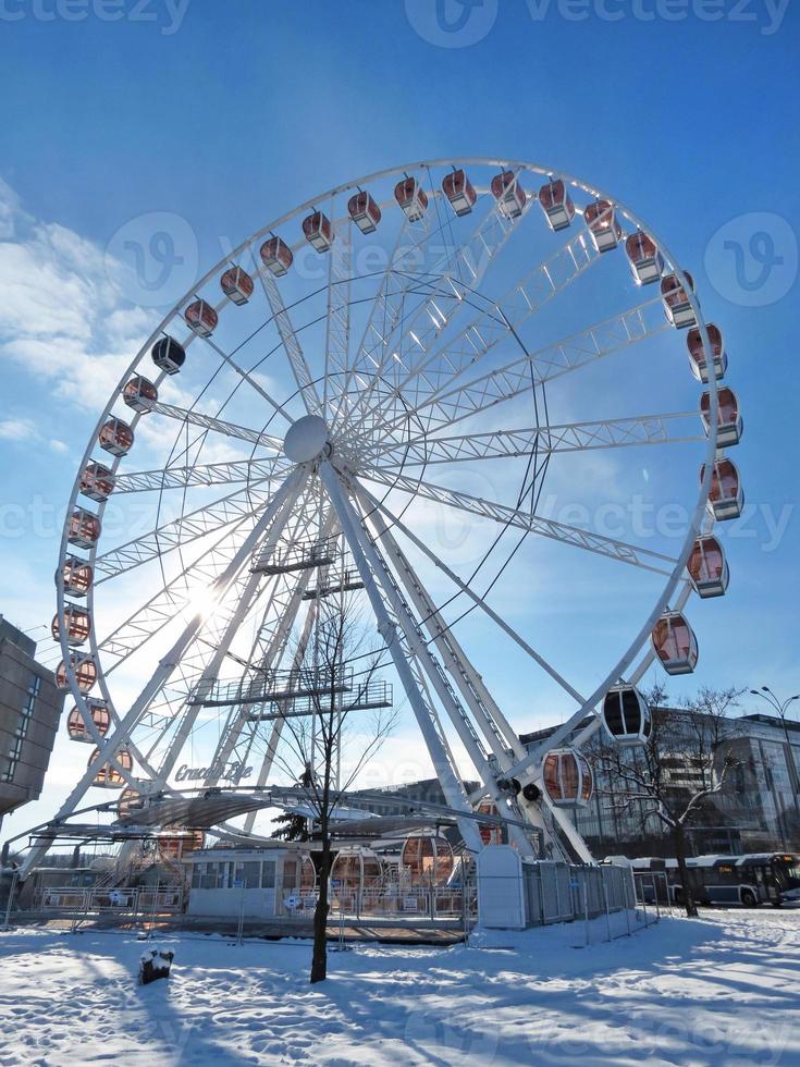 ferris hjul cracow öga i de bakgrundsbelysning mot en blå himmel med moln på frostig vinter- dag. vertikal botten se. Krakow, Polen, Europa. foto