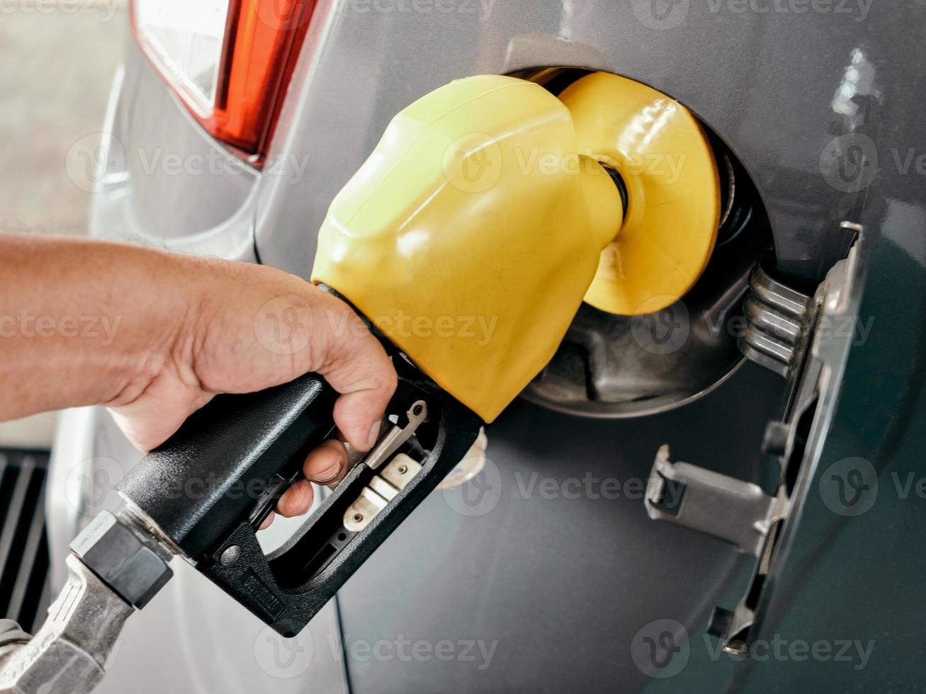 närbild se av en hänga innehav en bränsle pump på en gas station foto