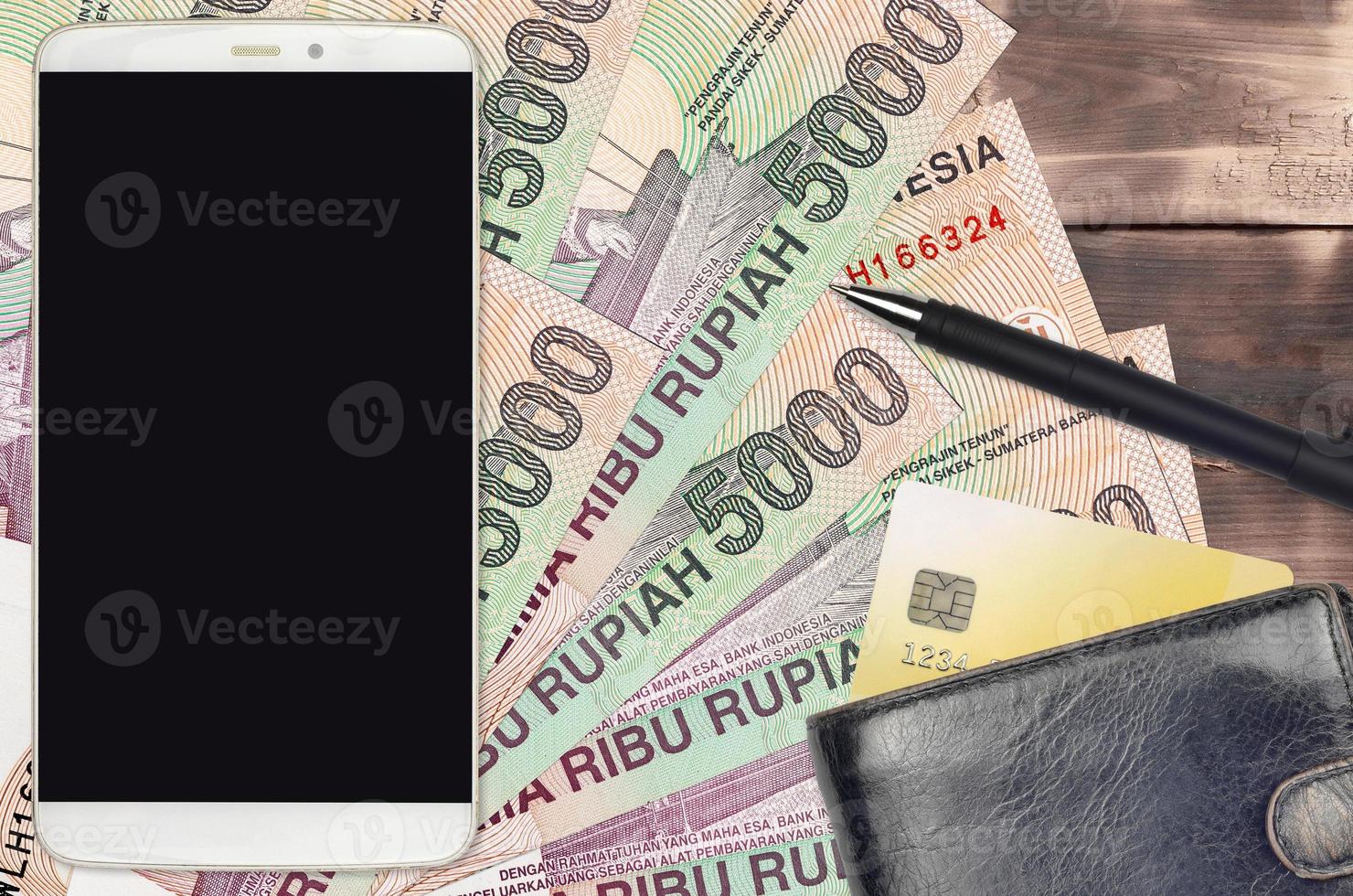 5000 indonesiska rupiah räkningar och smartphone med handväska och kreditera kort. e-betalningar eller e-handel begrepp. uppkopplad handla och företag med bärbar enheter foto