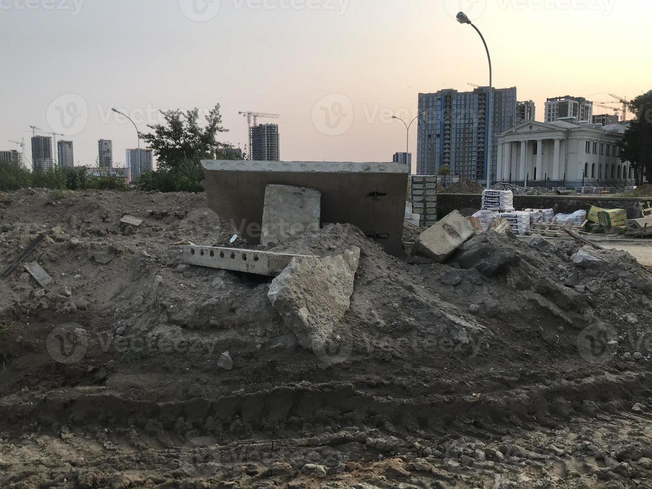 smuts på en konstruktion webbplats. sand fåror, spår från tung fordon. närliggande är byggnad material, bitar av betong och Övrig byggnad block, konstruktion avfall, miljö- förorening foto