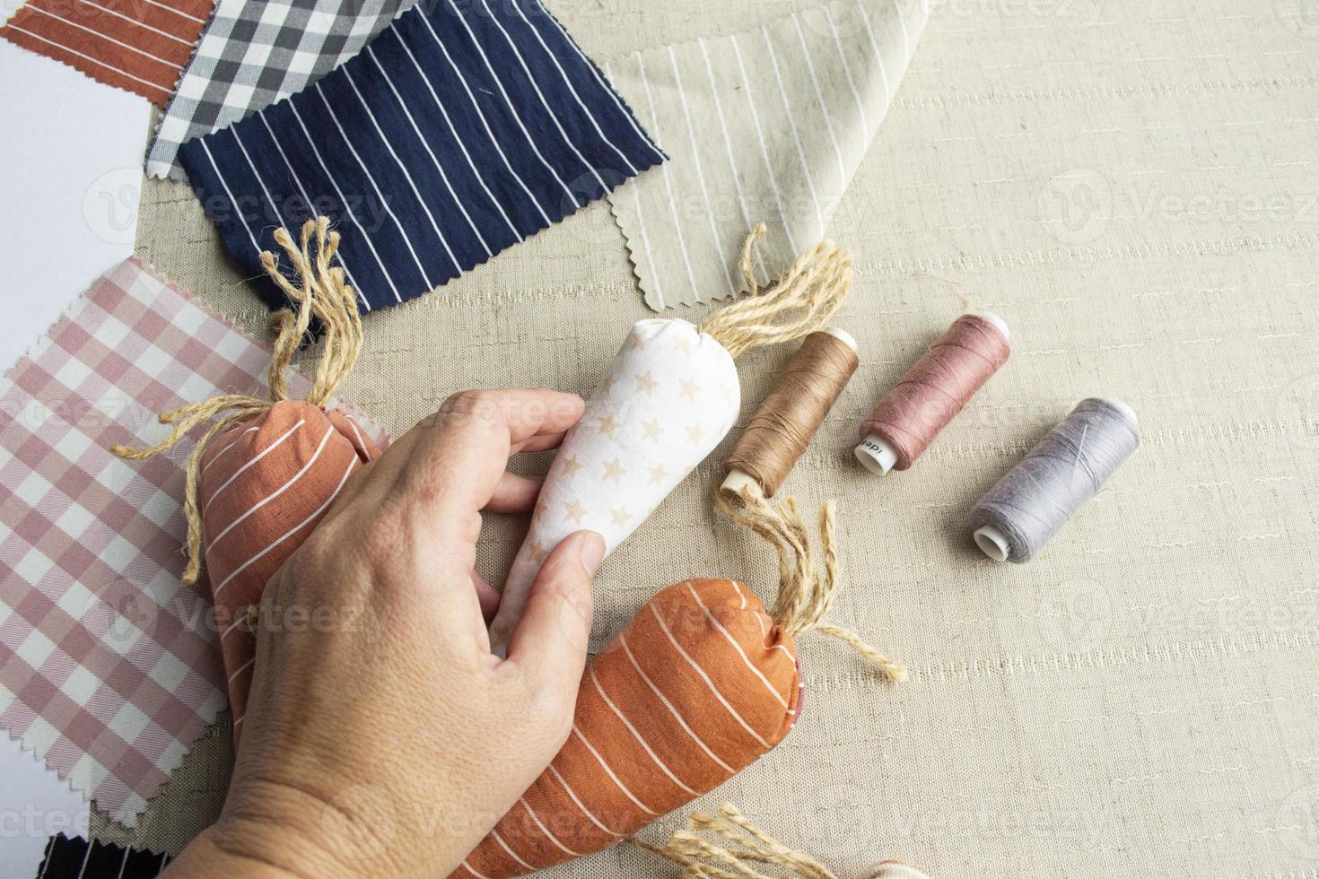 äldre kvinnas hand innehav tyg morot. påsk sömnad och handarbete, lätt och kreativ hantverk för familj, påsk Hem dekor foto