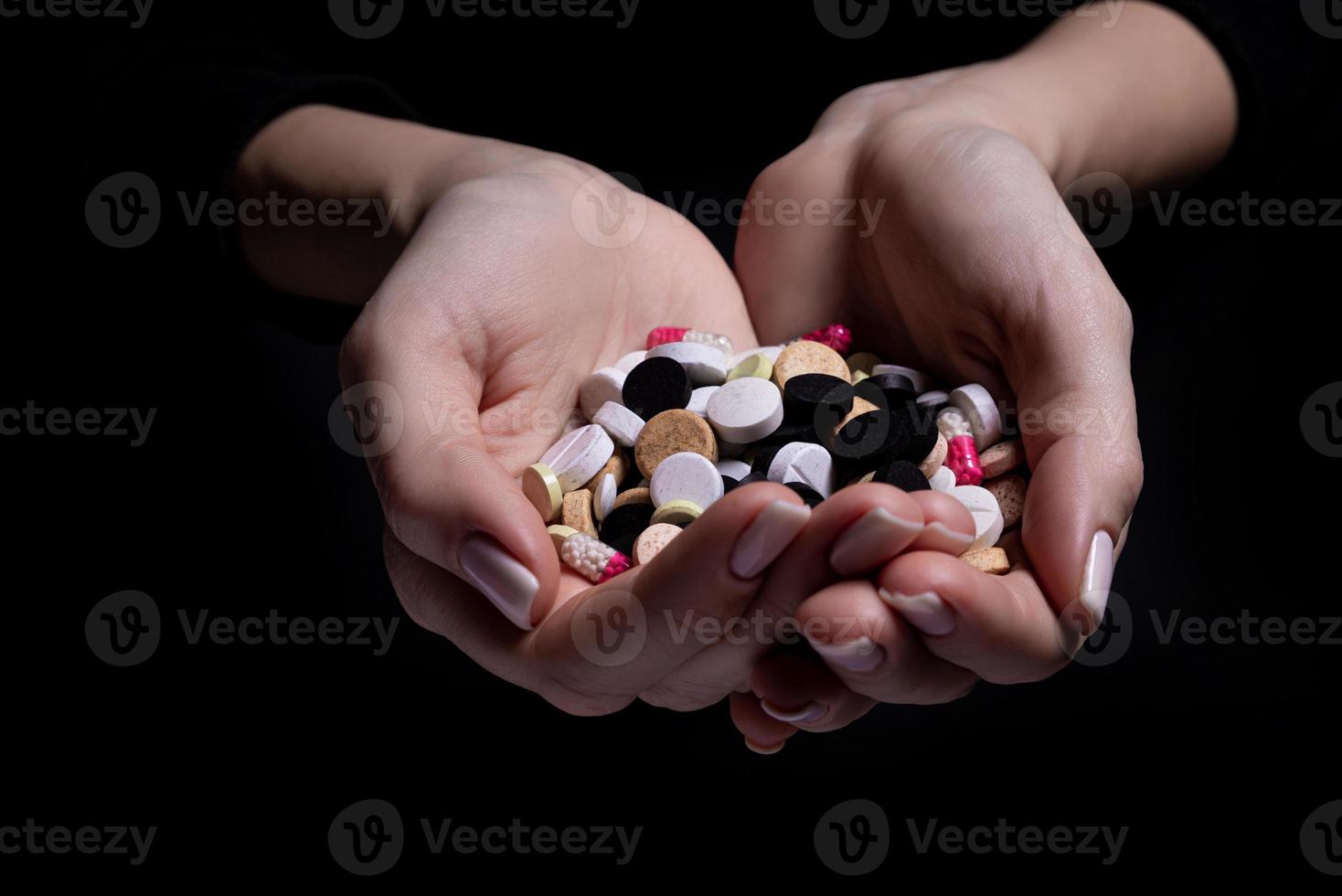 kvinna hand innehav piller på svart bakgrund foto