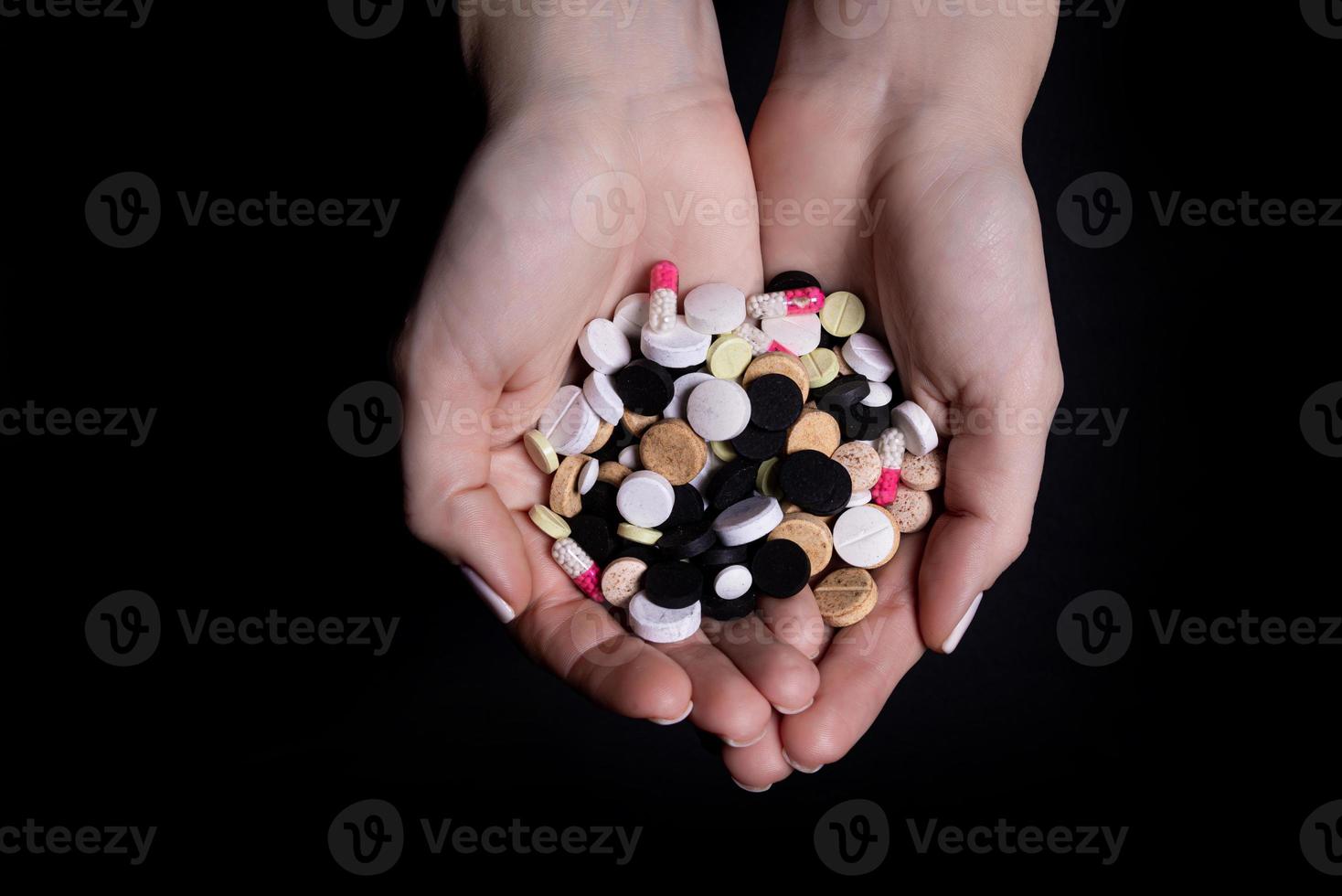 kvinna hand innehav piller på svart bakgrund foto