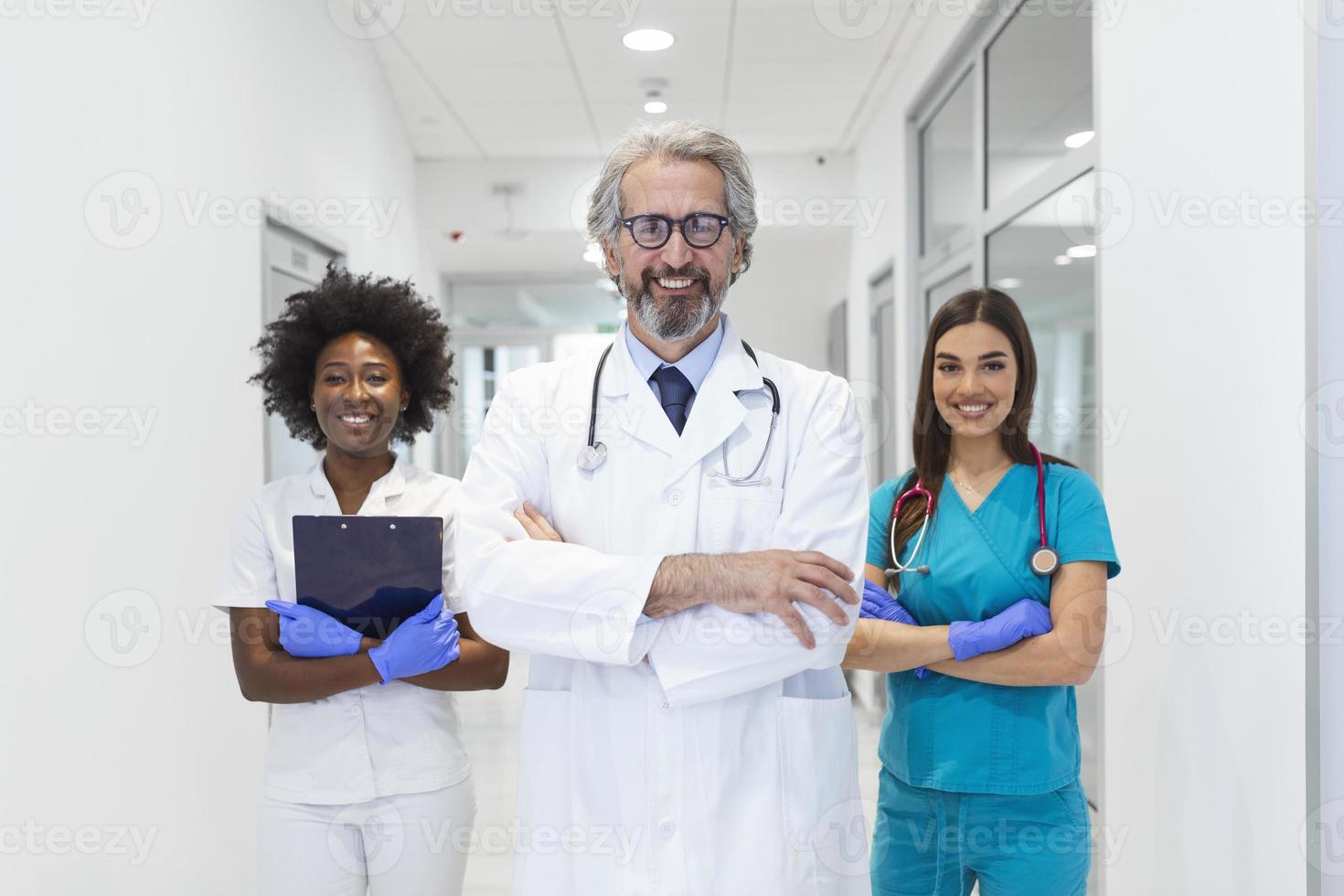 framgångsrik team av medicinsk doktorer är ser på kamera och leende medan stående i sjukhus foto