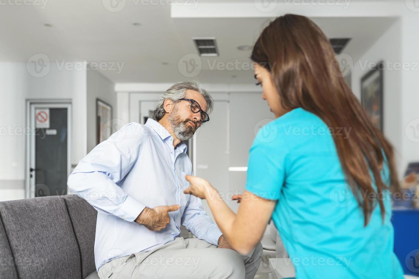 patient klagar till de läkare handla om hans abdominal smärta och Övrig symtom. ung kvinna läkare diagnostiseras henne patient. sjukhus väntar rum foto