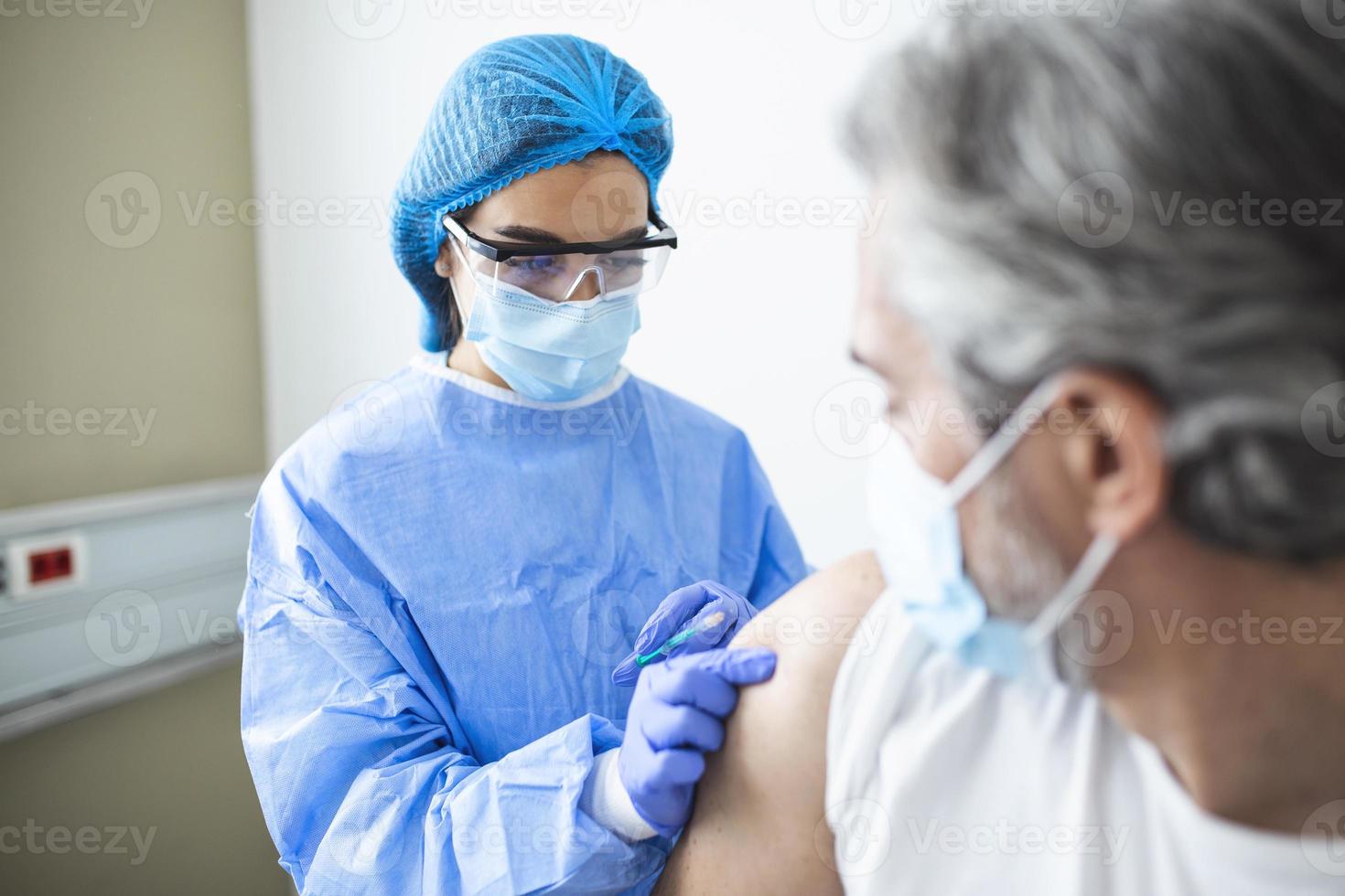 läkare bär ppe kostym och kirurgisk mask och använda sig av vaccin med smittad patient i karantän rum covid-19 coronavirus utbrott eller covid19, begrepp av covid-19 karantän foto