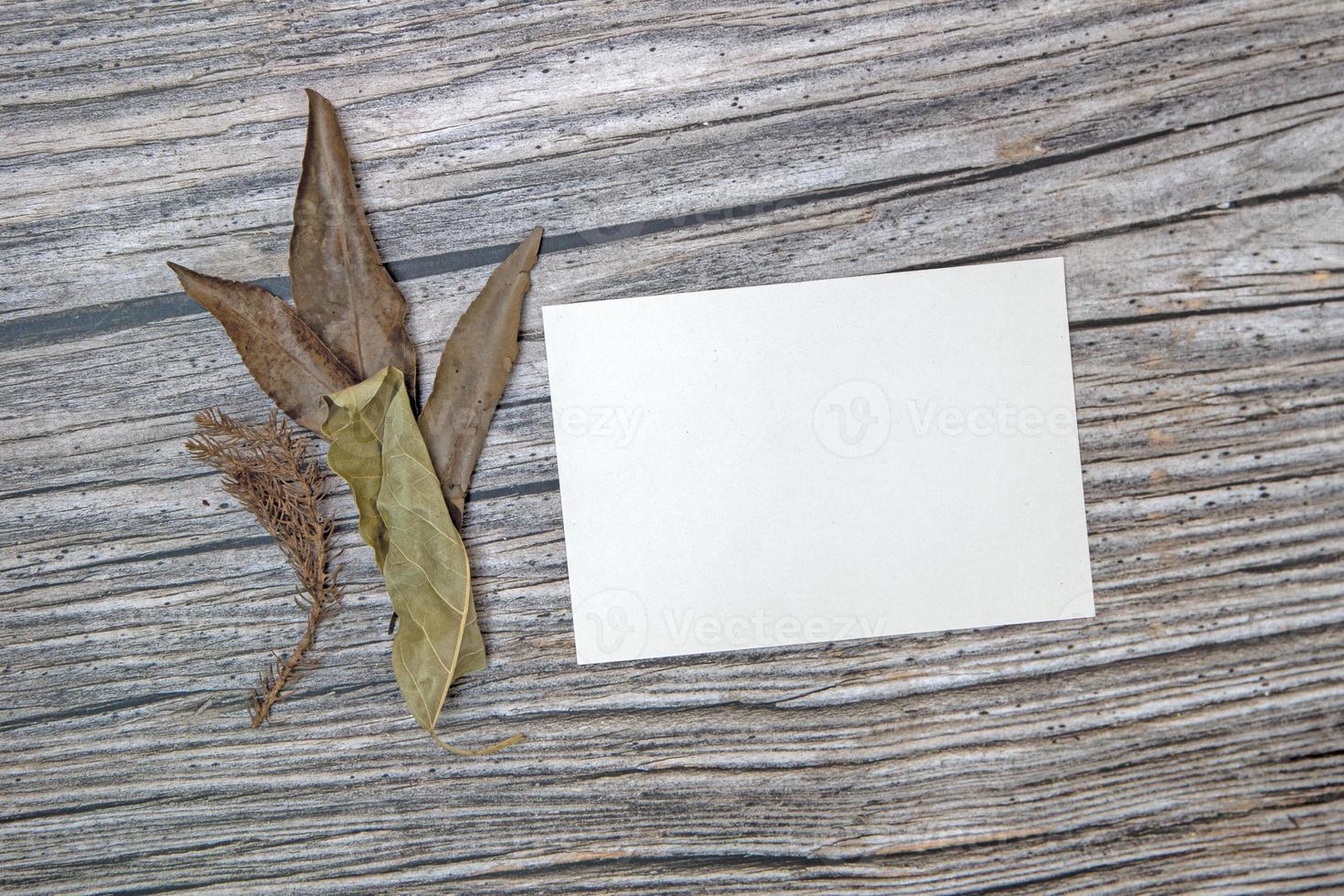 a5 papper hälsning kort attrapp med torr löv på trä- bakgrund foto