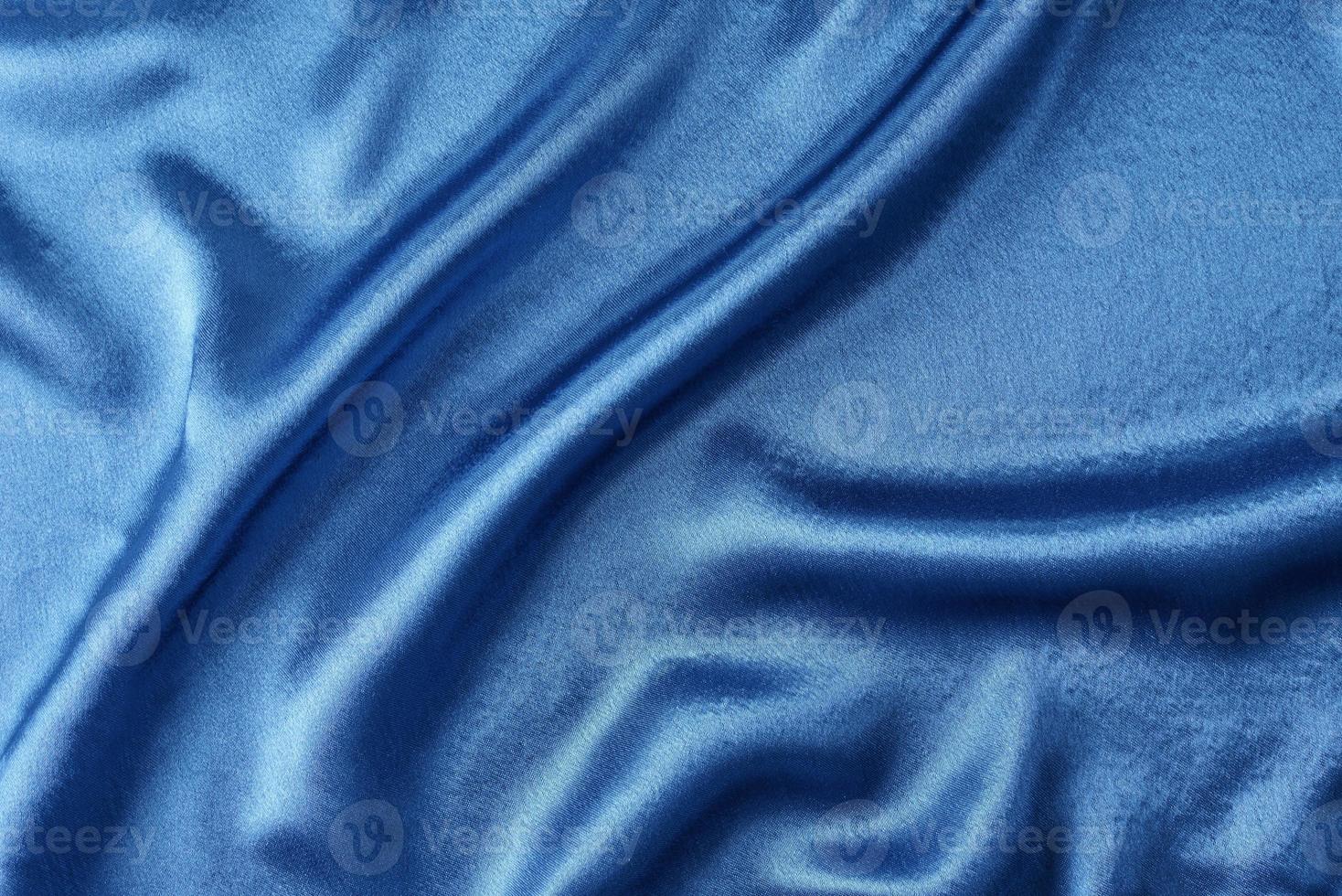 blå silke bakgrund med en veck. abstrakt textur av krusigt satin yta foto
