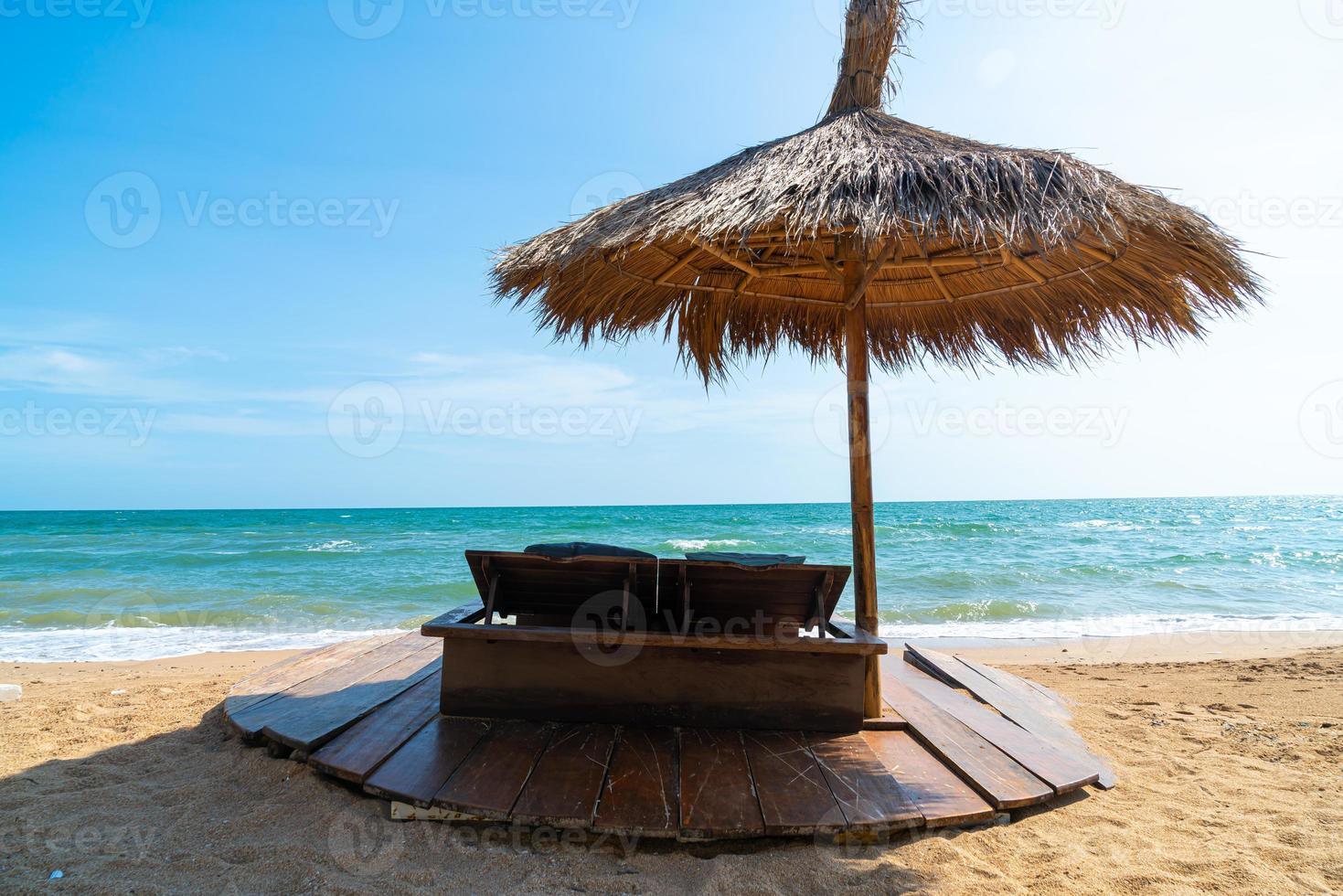 strandstol och paraply med havsstrandbakgrund foto