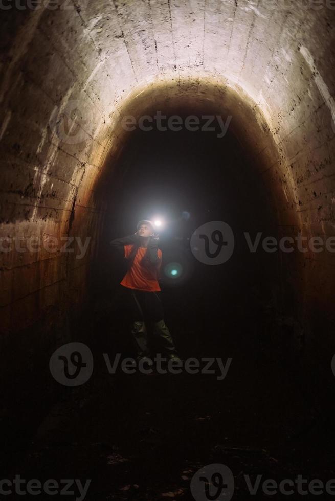 kvinna grävare med ficklampa utforskar de tunnel foto