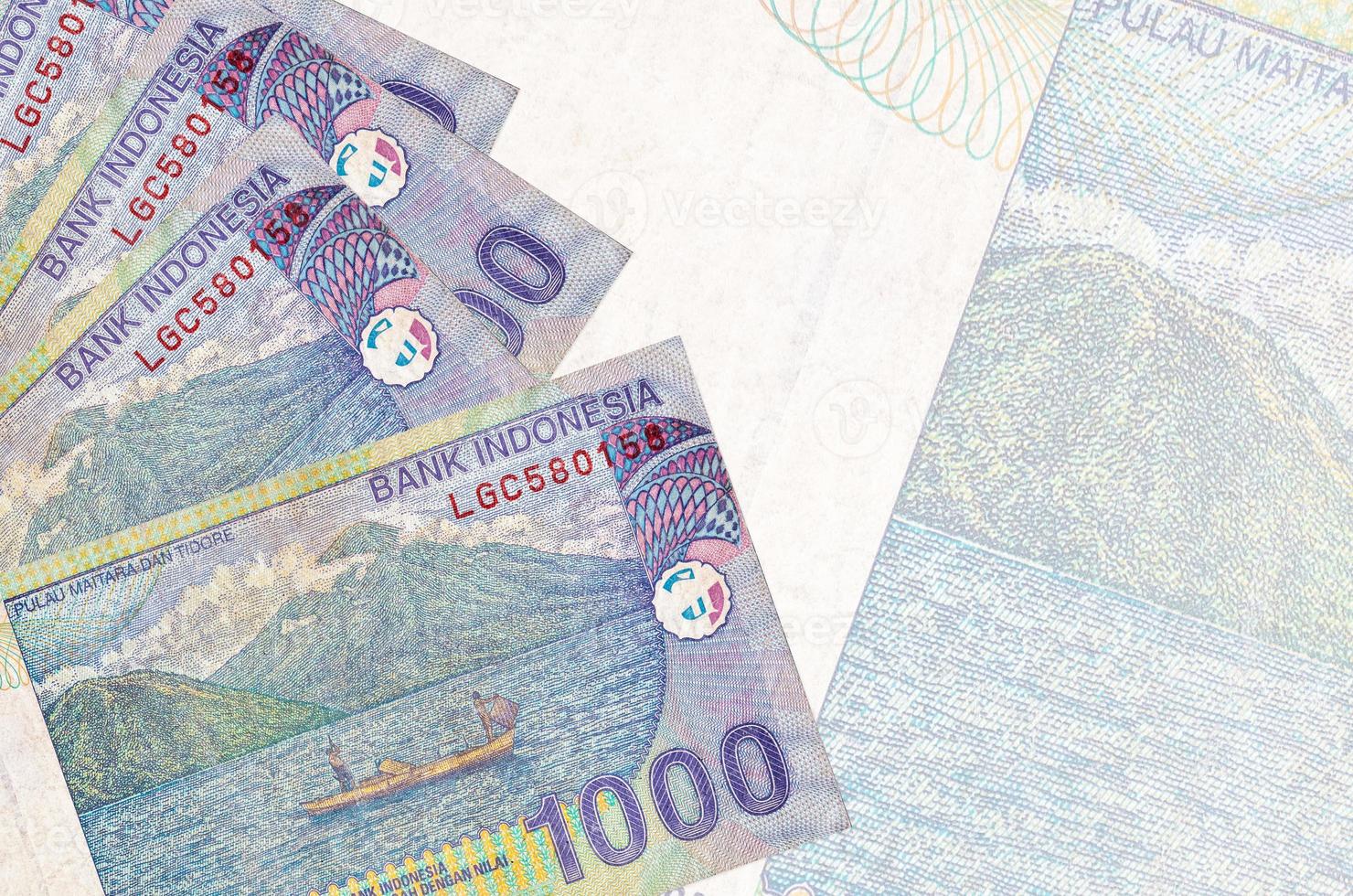 1000 indonesiska rupiah räkningar lögner i stack på bakgrund av stor halvtransparent sedel. abstrakt företag bakgrund foto