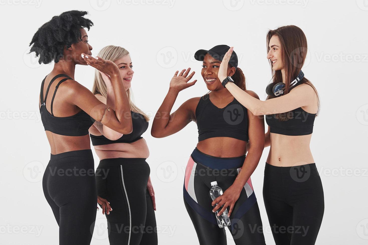 bra jobbat efter träningen. grupp av multietniska kvinnor står i studion mot vit bakgrund foto