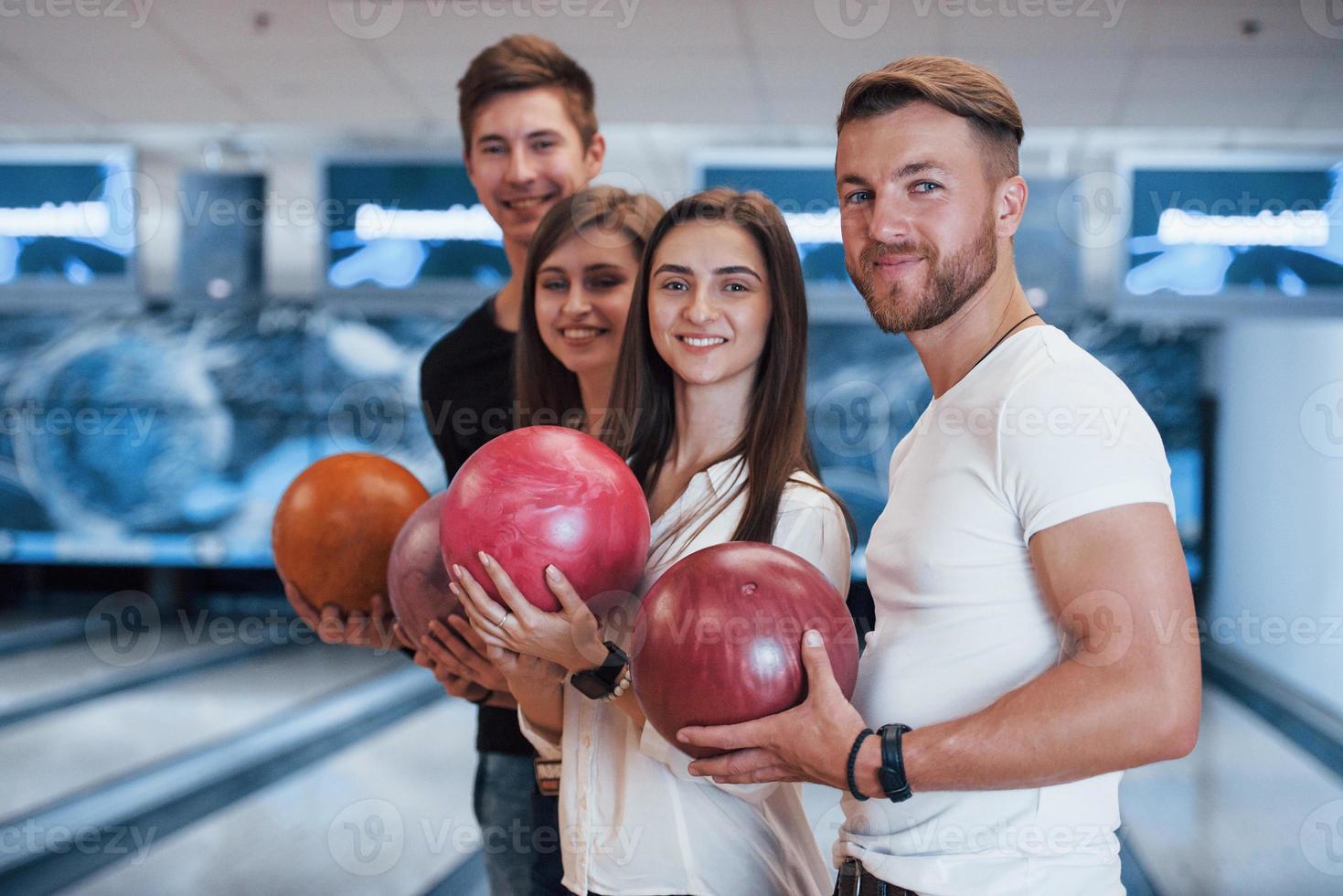 sidovy. unga glada vänner har kul i bowlingklubben på sina helger foto