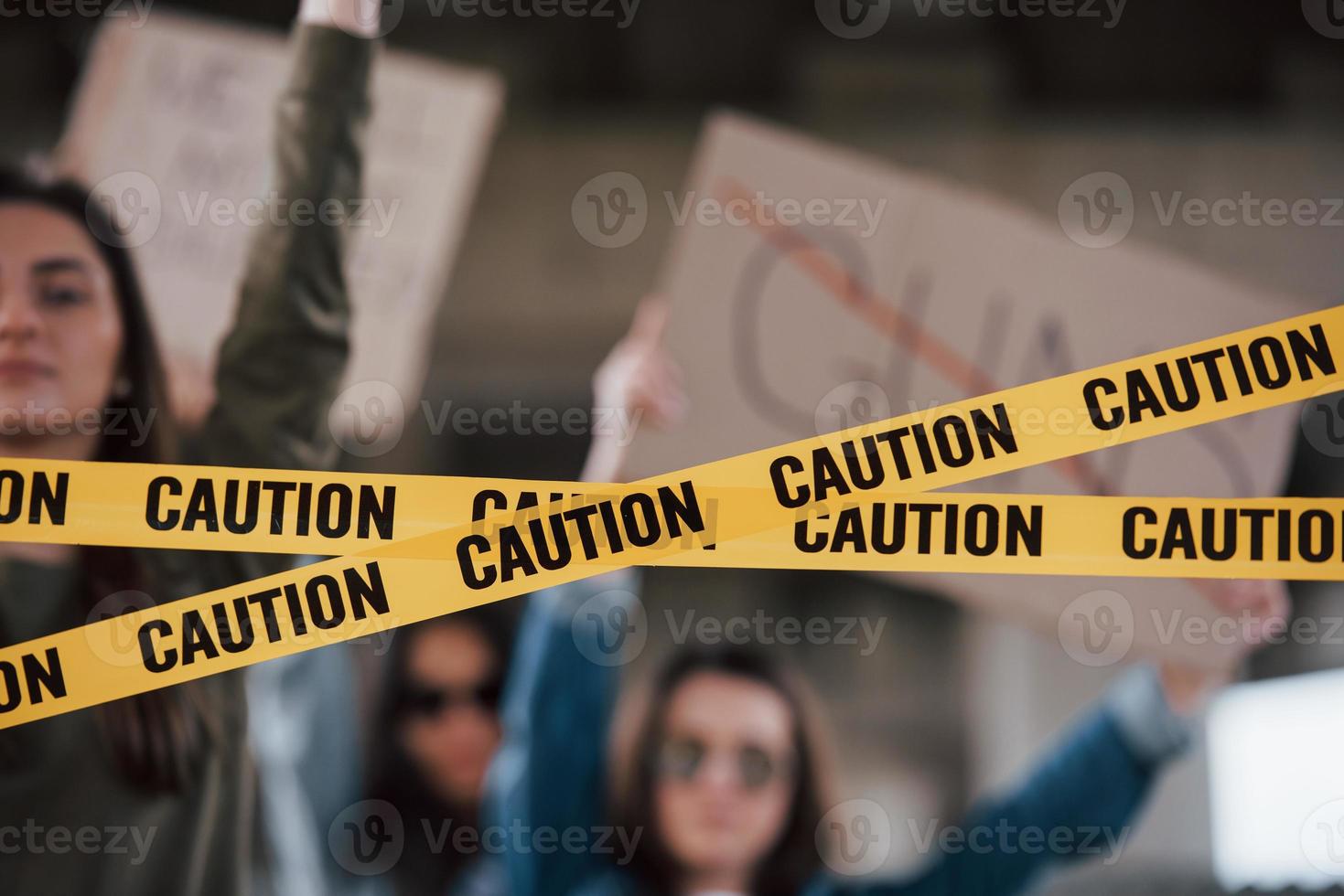 detaljerad vy på gul tejp. grupp feministiska kvinnor protesterar för sina rättigheter utomhus foto