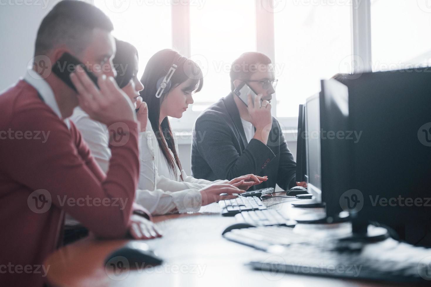 fint väder ute. ungdomar som arbetar i callcenter. nya erbjudanden kommer foto