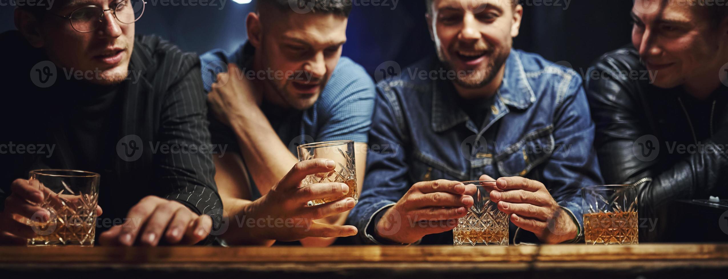 främre se. vänner vilar i de pub med alkohol i händer. har konversation foto