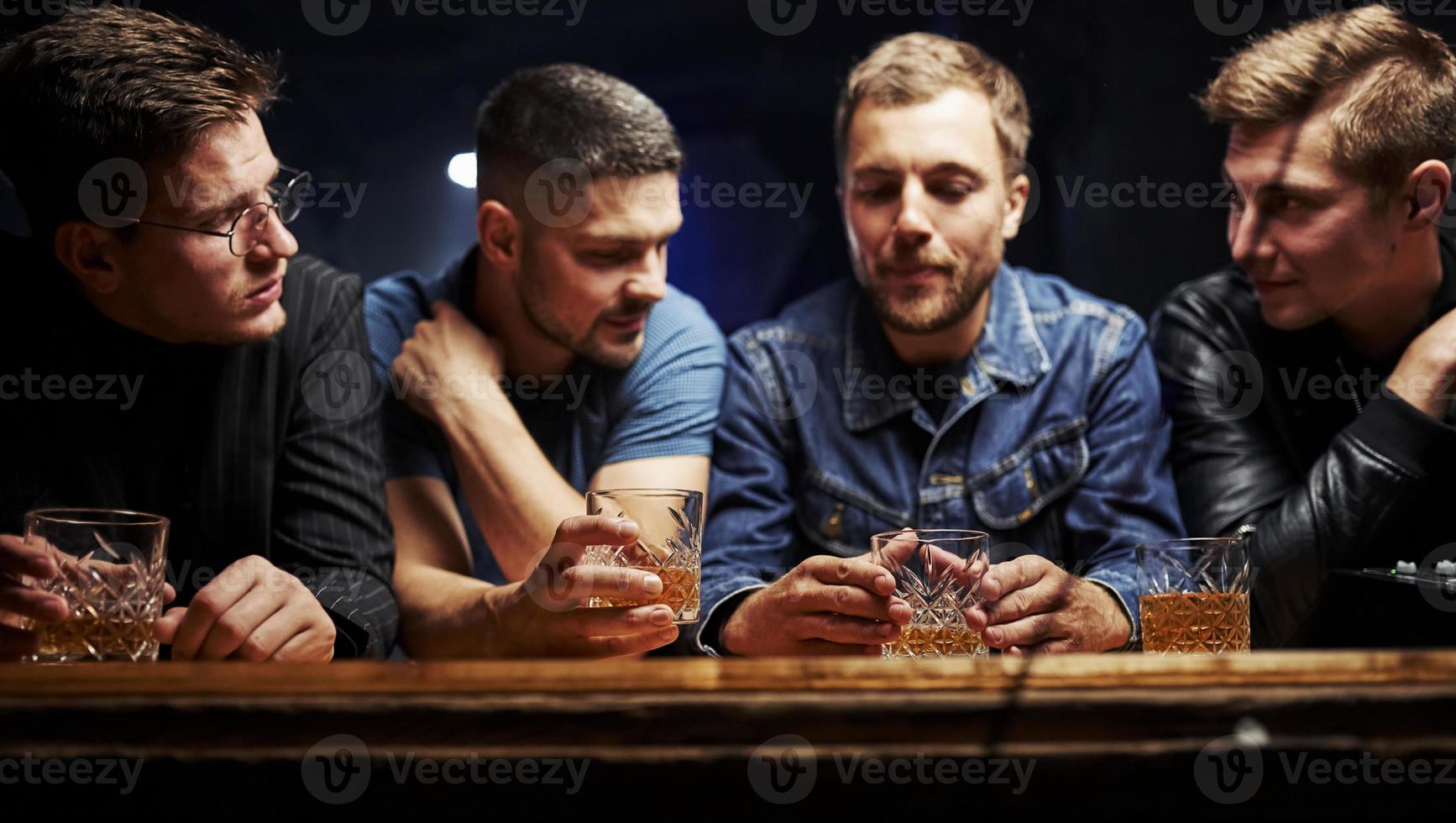 främre se. vänner vilar i de pub med alkohol i händer. har konversation foto