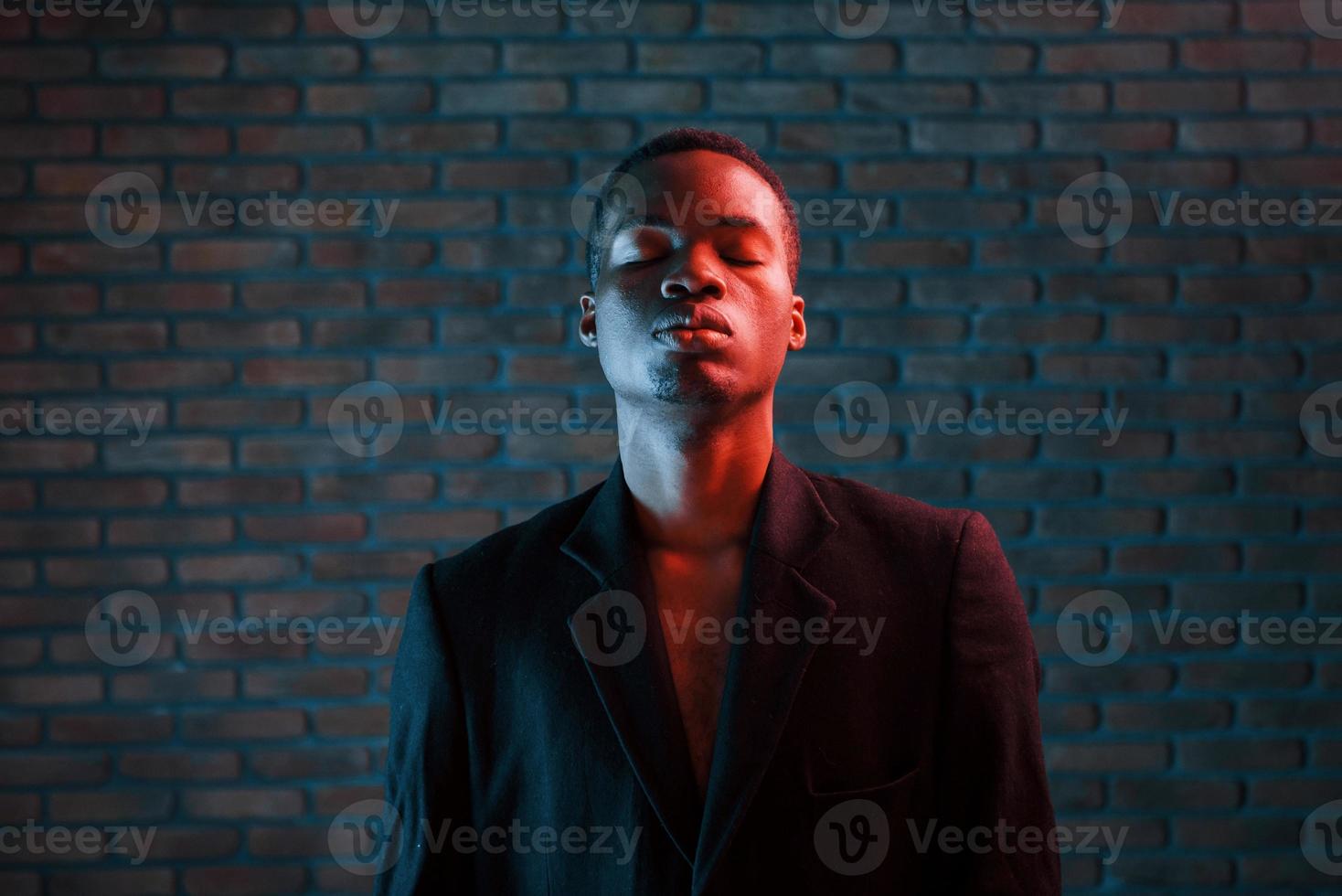 trogen neon belysning. ung afrikansk amerikan man i de studio foto