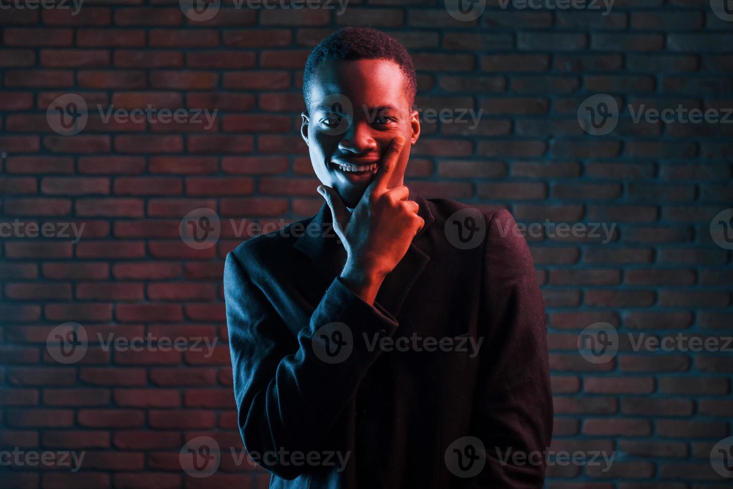 trogen neon belysning. ung afrikansk amerikan man i de studio foto