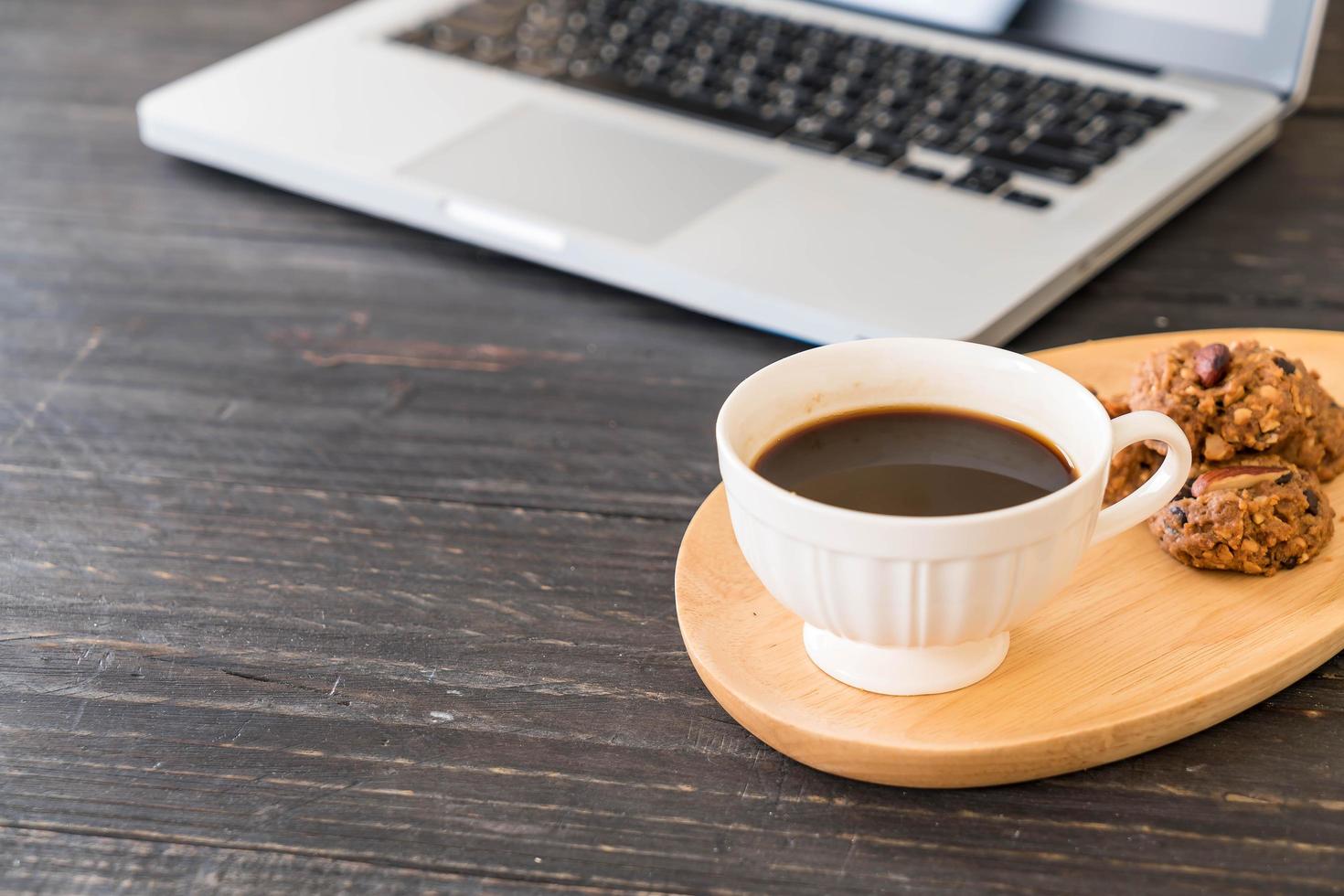 svart kaffe och kakor med en bärbar dator foto