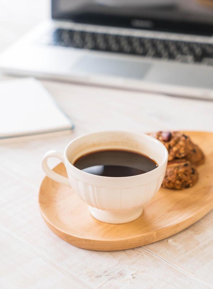 kaffe och kakor med en bärbar dator och en anteckningsbok foto