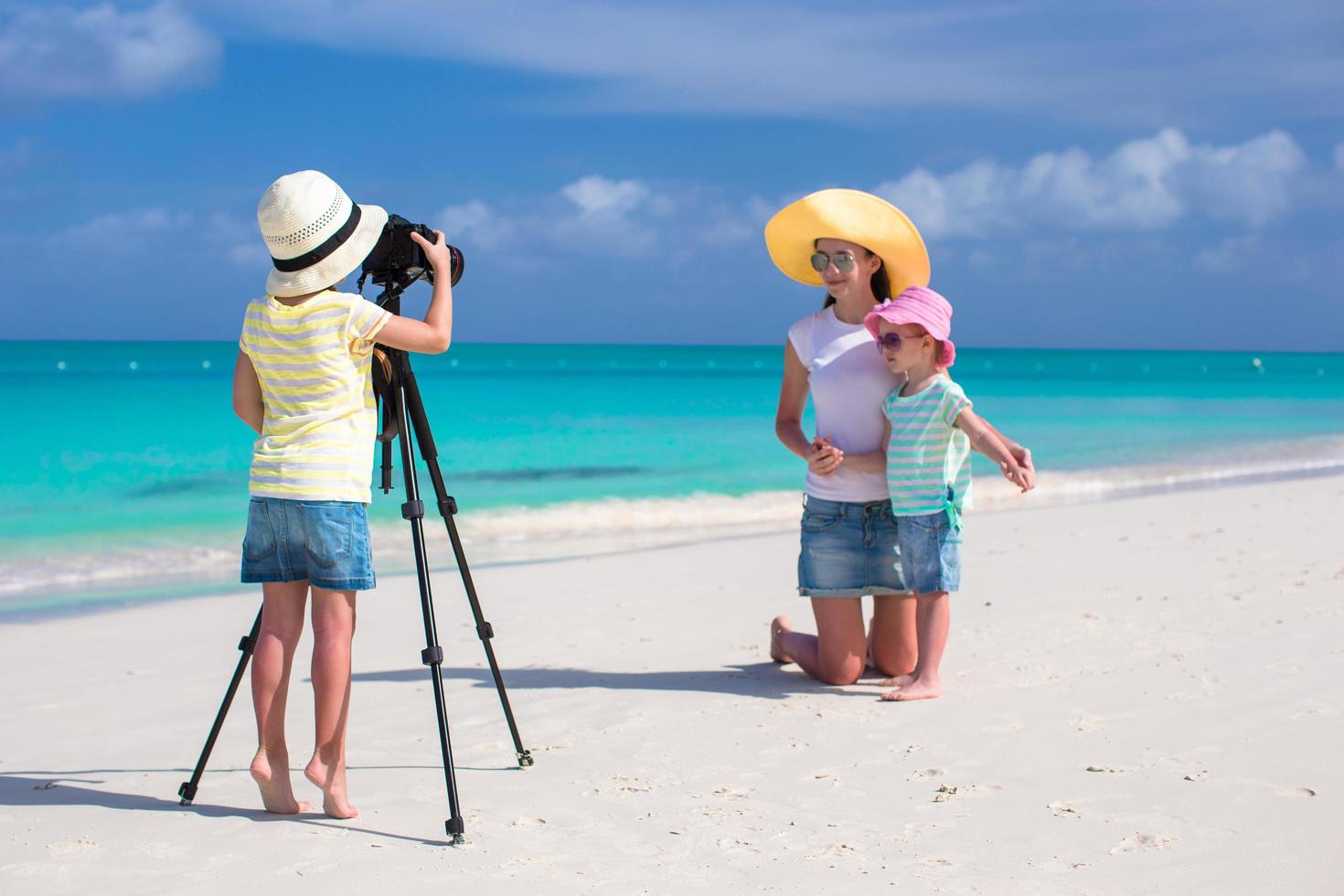 familj som tar semesterbilder på en strand foto