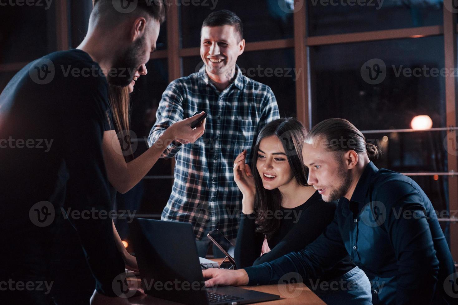 nöje till arbete med du. team av ung företag människor ha några jobb på deras projekt på natt tid i de kontor foto