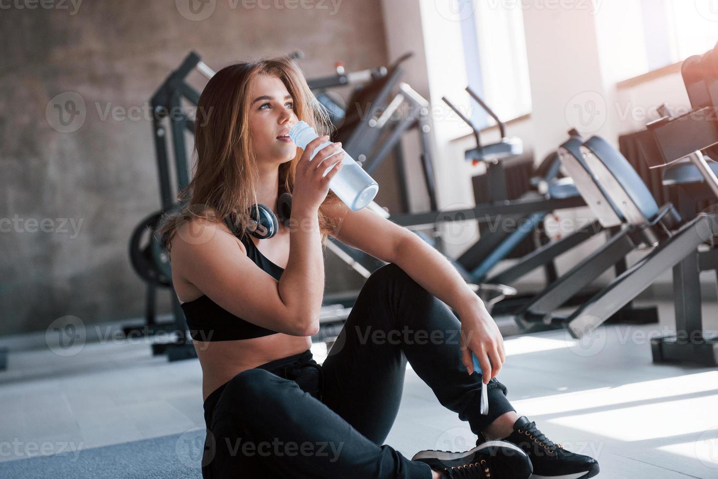 dricka vatten. Foto av underbar blond kvinna i de Gym på henne helgen tid