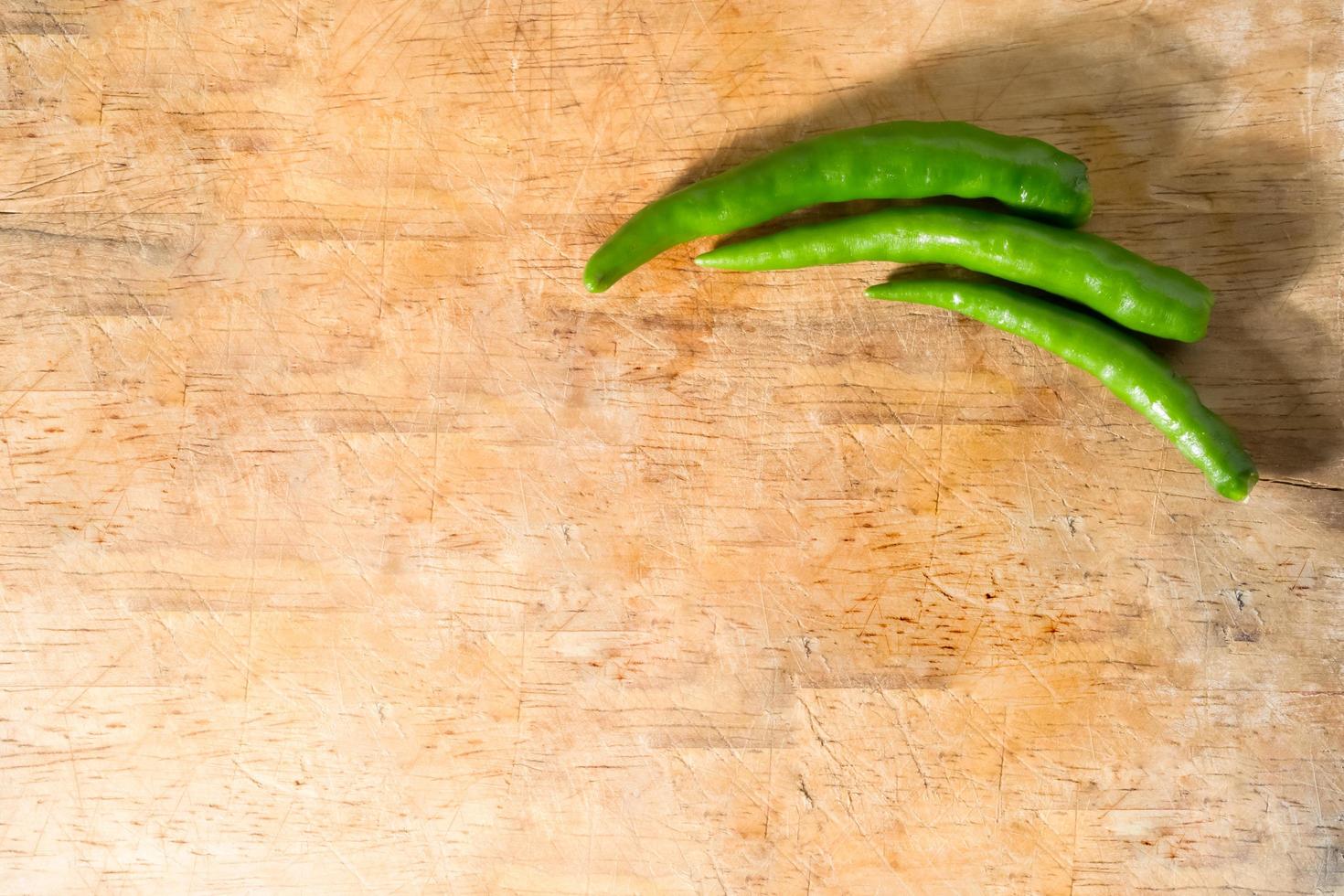 grön chili på träbakgrund foto