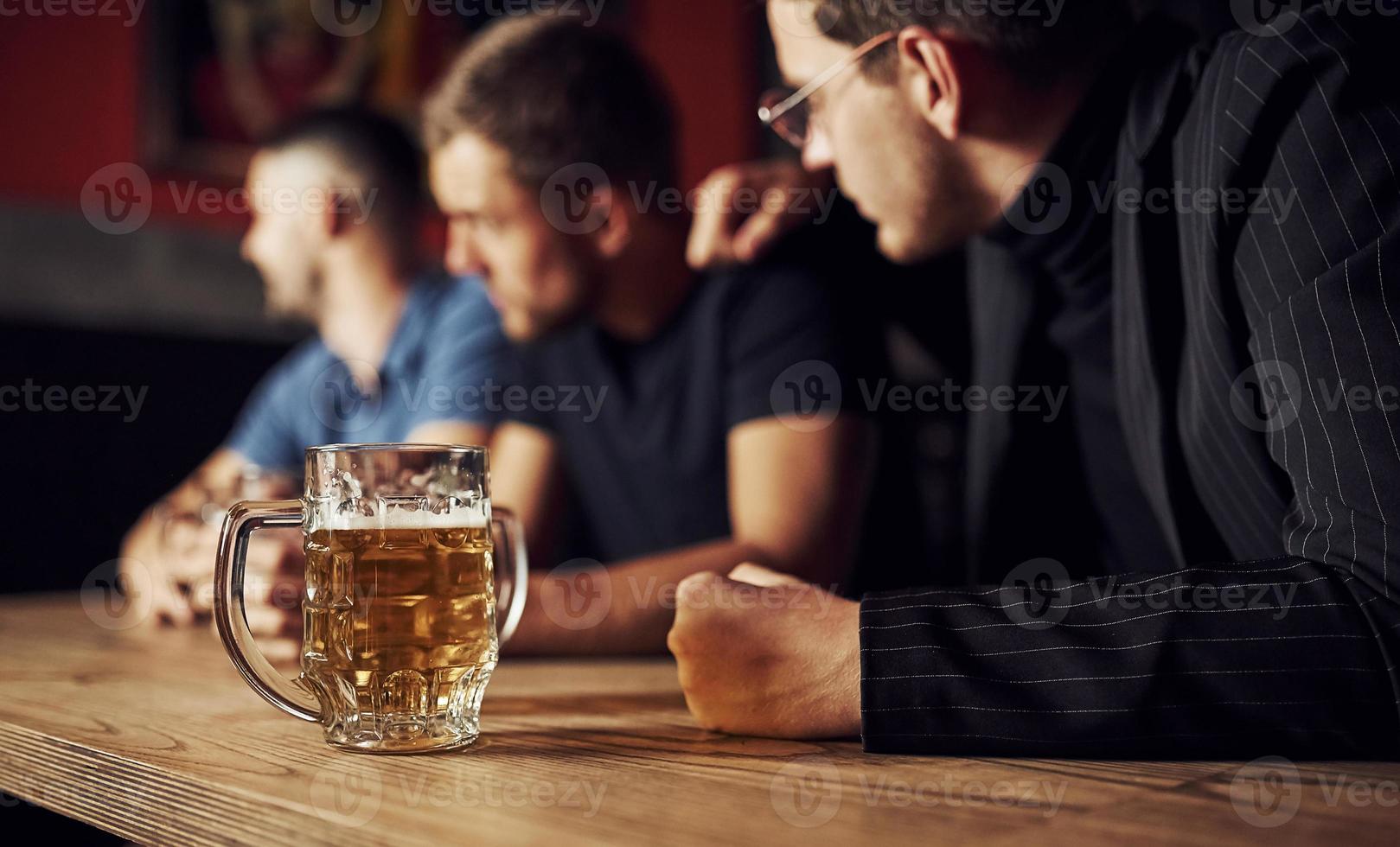 tre manlig vänner i de bar. stödjande ledsen vän. enhet av människor. med öl på de tabell foto